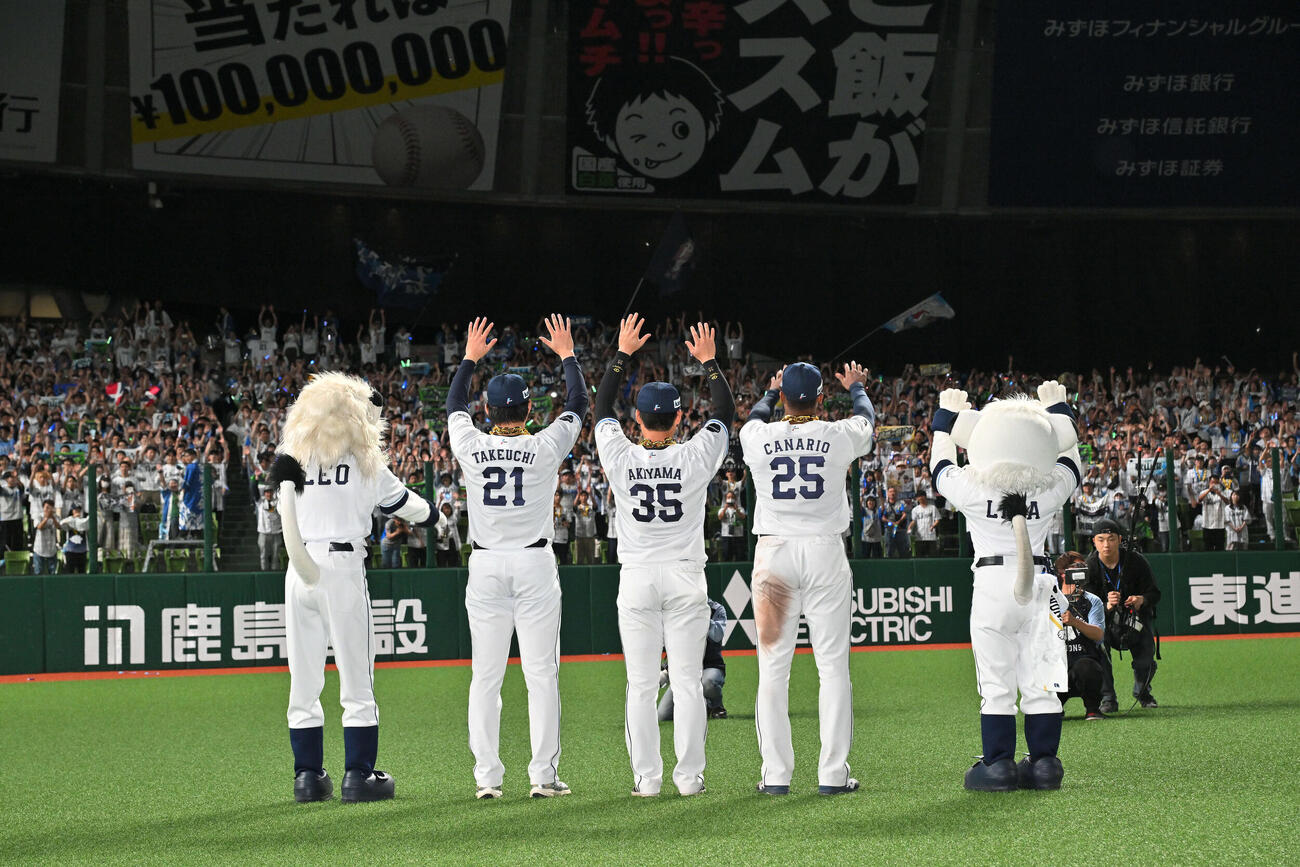 西武対ロッテ　試合後、ファンと勝利を祝う西武の、左から武内、秋山、カナリオ（撮影・滝沢徹郎）
