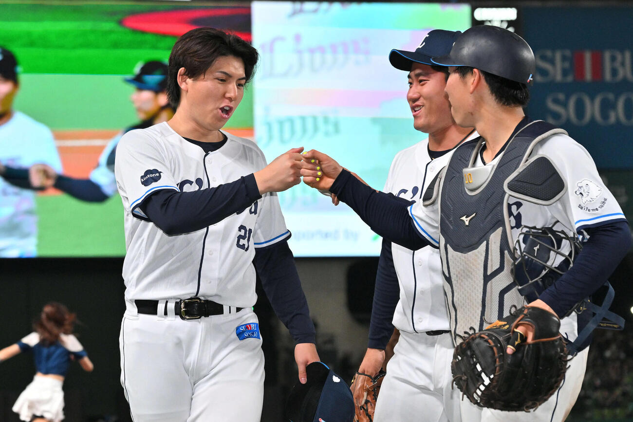 西武対ロッテ　試合後、勝利投手の西武武内（左）は小島とタッチを交わす。中央は岩城（撮影・滝沢徹郎）