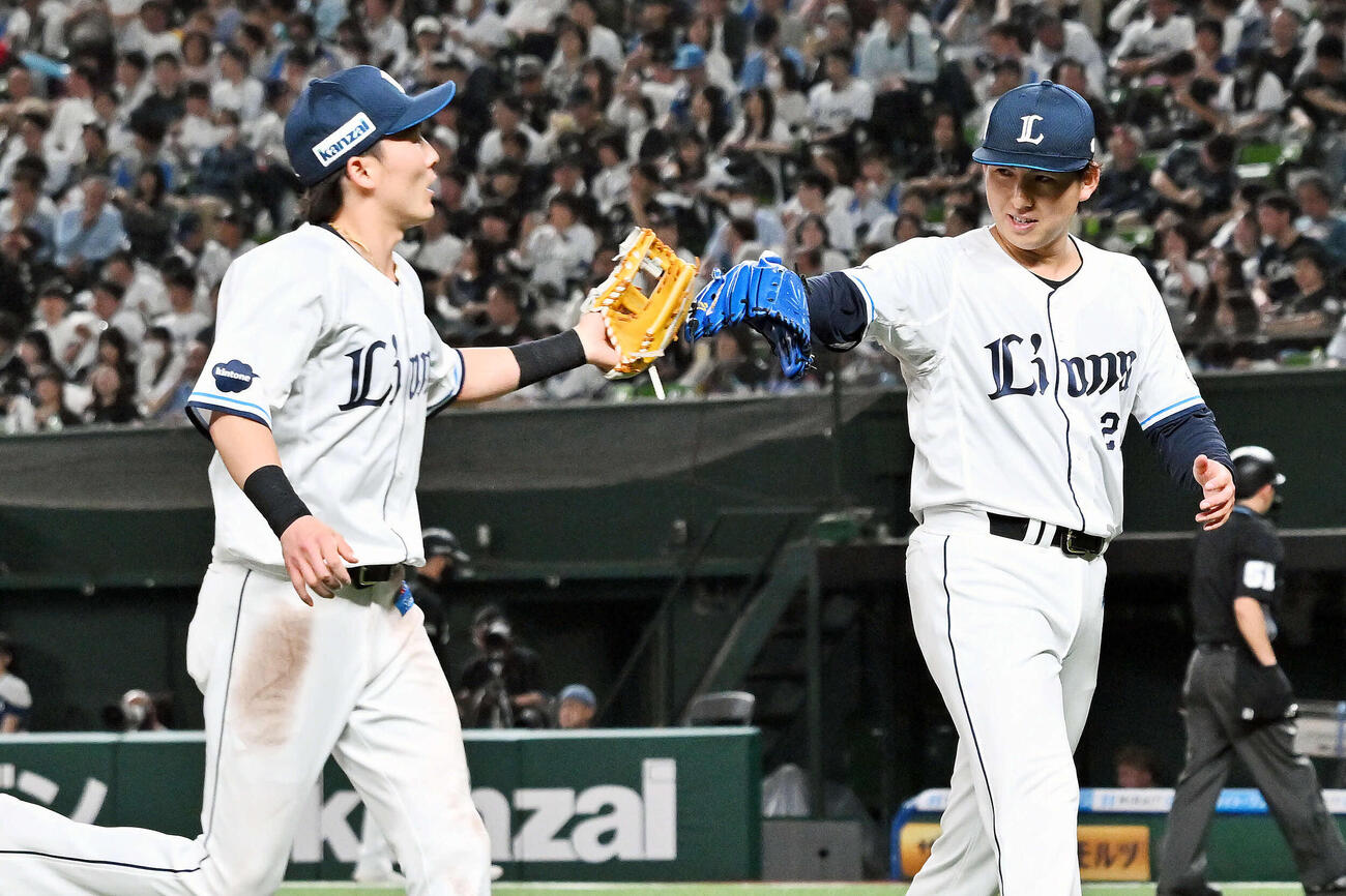 西武対ロッテ　7回裏を投げ終えた西武先発の武内（右）は源田とタッチを交わす（撮影・滝沢徹郎）