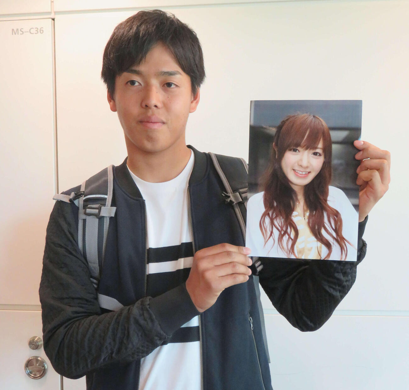 妻の写真を手に笑顔を見せる杉浦稔大（2017年1月21日撮影）
