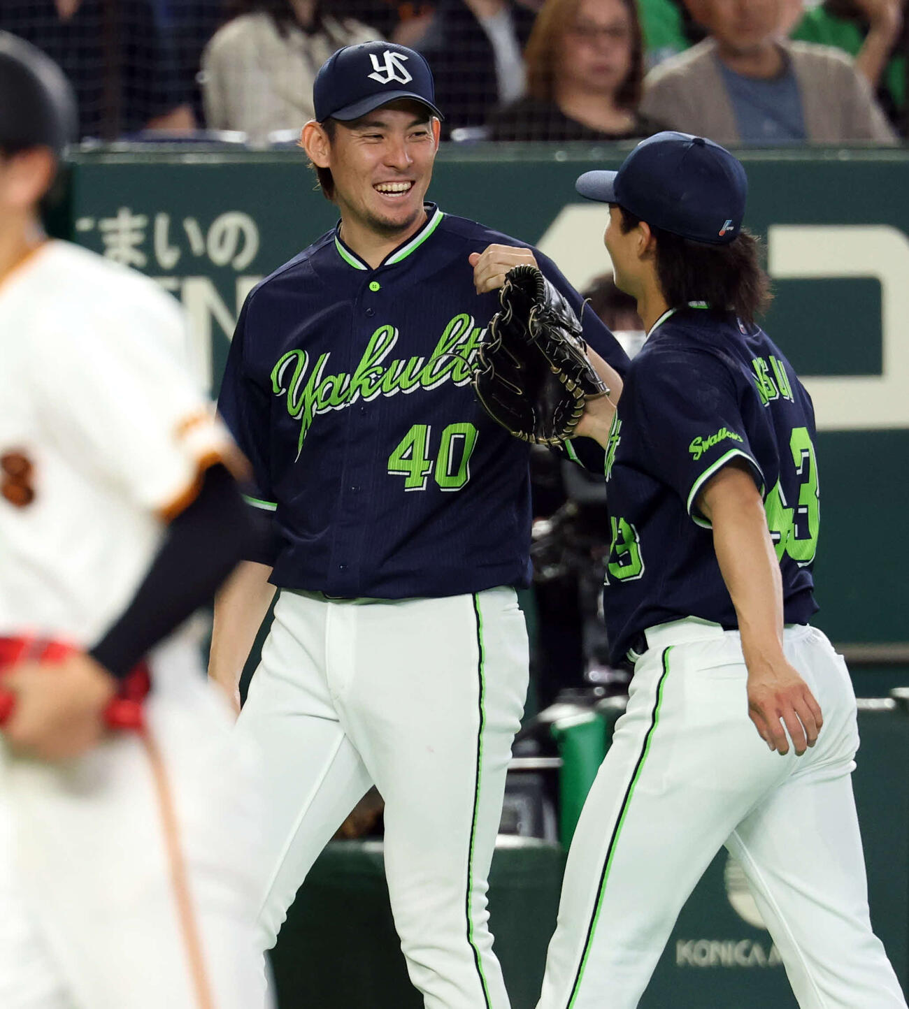 巨人対ヤクルト　8回裏巨人2死一、二塁、佐々木を三振に仕留めた増居（右）を笑顔で迎える高梨（撮影・浅見桂子）