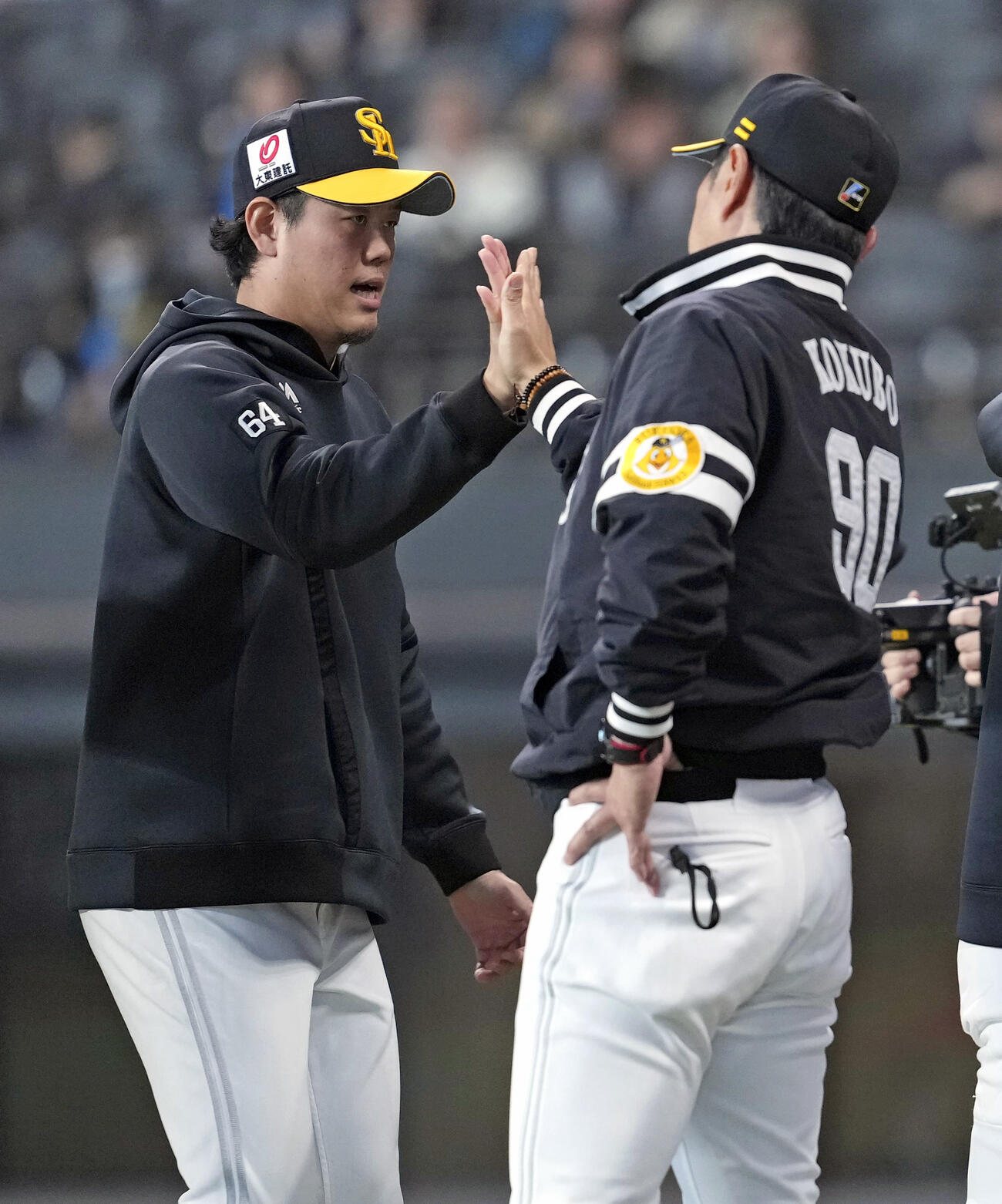 日本ハムに勝利し小久保監督（右）とタッチを交わすソフトバンク上茶谷（共同）