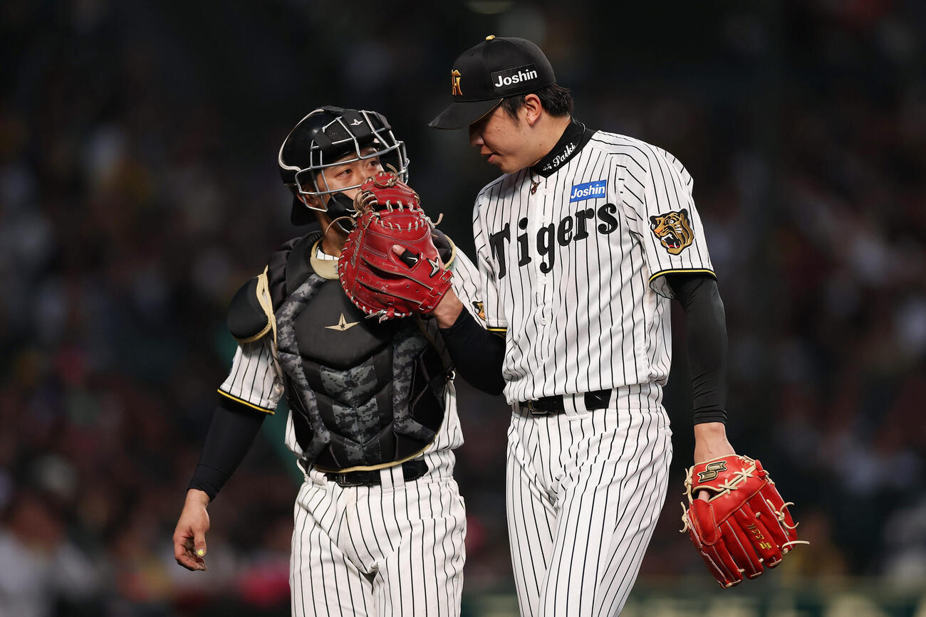 阪神対巨人　2回表を投げ終え、坂本（左）と言葉を交わしながらベンチへ戻る阪神才木（撮影・前田充）