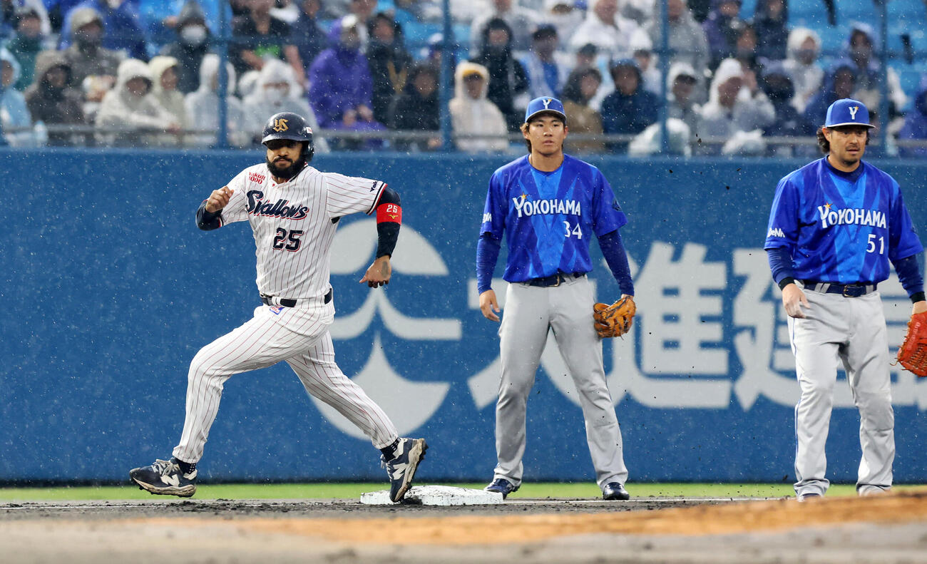ヤクルト対DeNA 1回裏ヤクルト1死一塁、一塁走者サンタナは宮崎（右）が古賀の打球を一塁へ悪送球したことを確認し一気に本塁へ生還する。中央は宮下（撮影・加藤哉）
