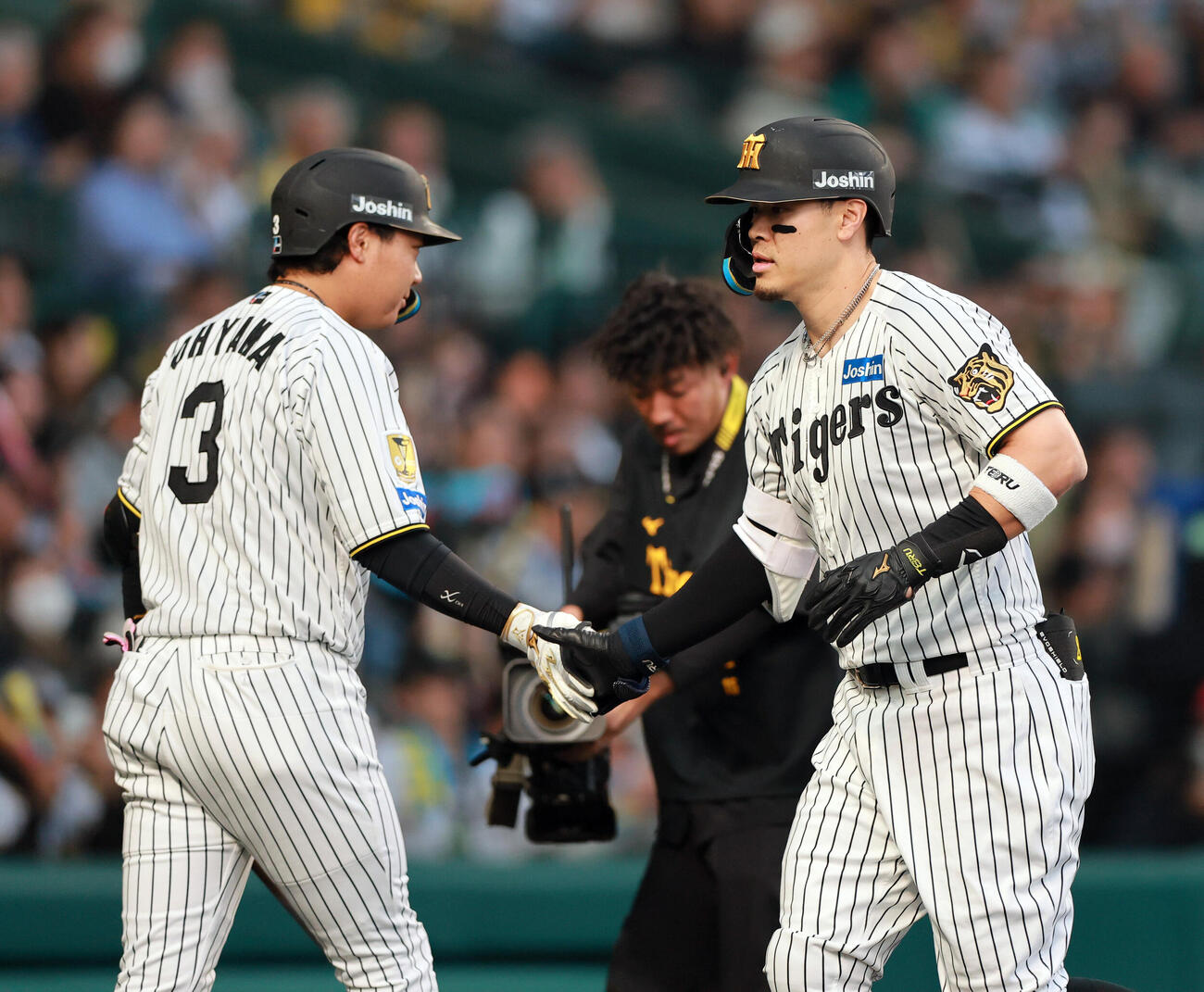 阪神対巨人　1回裏阪神2死一塁、佐藤（右）は2点本塁打を放ち次打者の大山とタッチをかわす（撮影・上山淳一）
