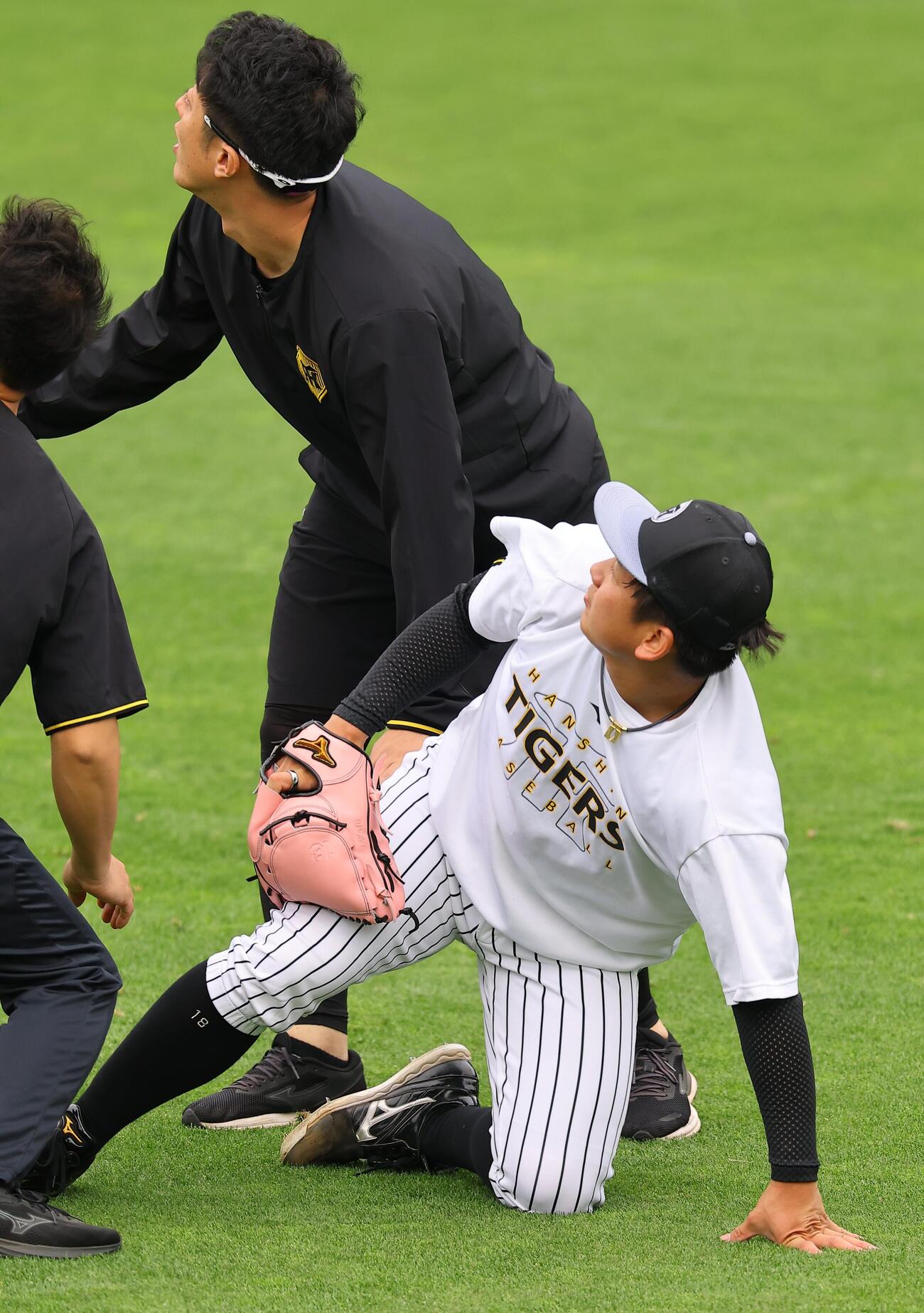 打球が右足に当たりグラウンドに倒れ込む伊原（撮影・上田博志）