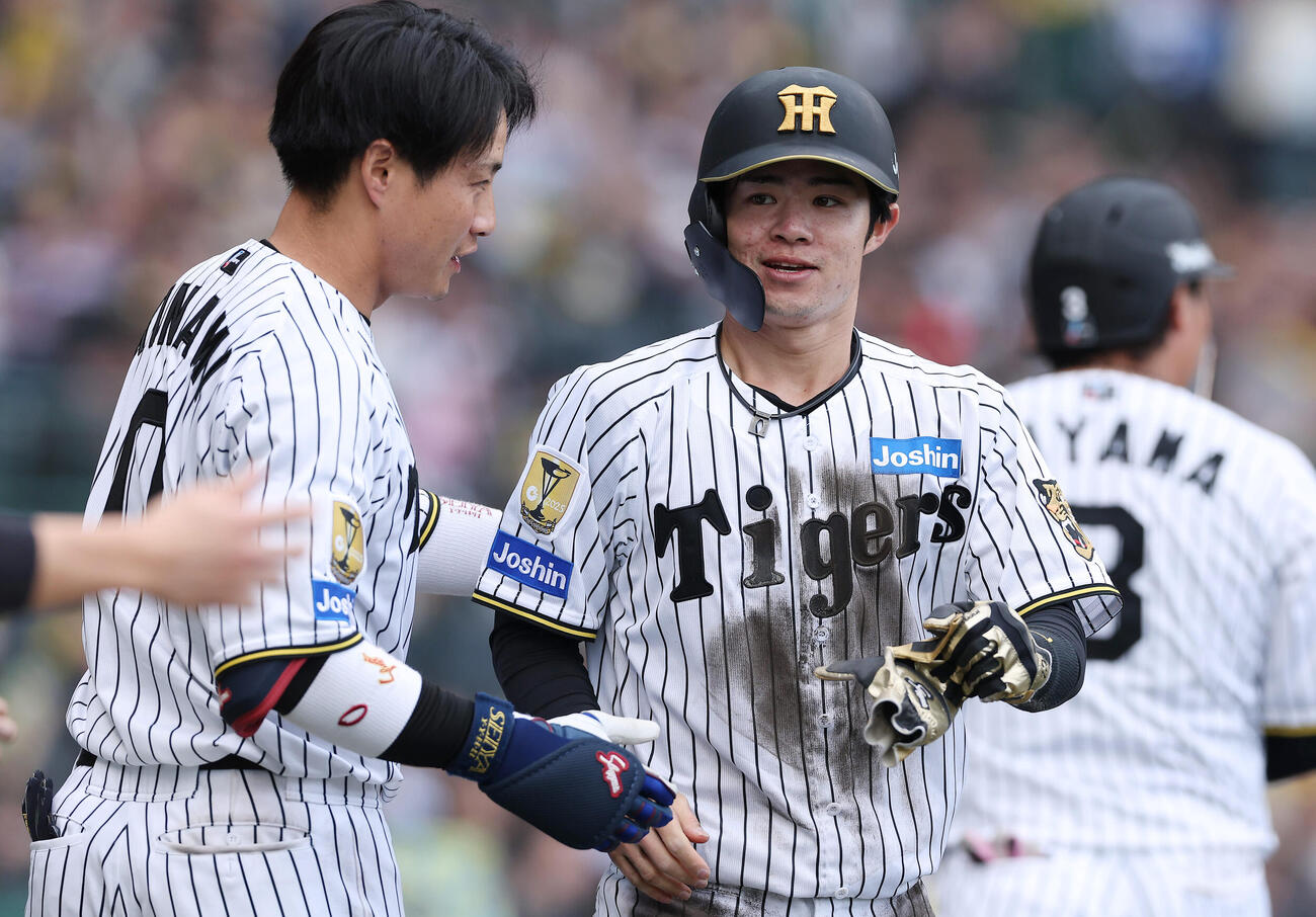 阪神対中日　7回裏阪神1死一塁、森下の適時二塁打で生還しナインに迎えられる中野（右）（撮影・前田充）