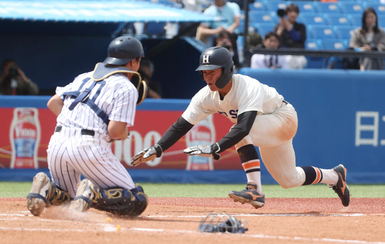 法大対立大　2回表法大1死一、三塁、境の遊ゴロが野手選択になり三塁走者土肥がヘッドスライディングで生還する。捕手落合（撮影・柴田隆二）