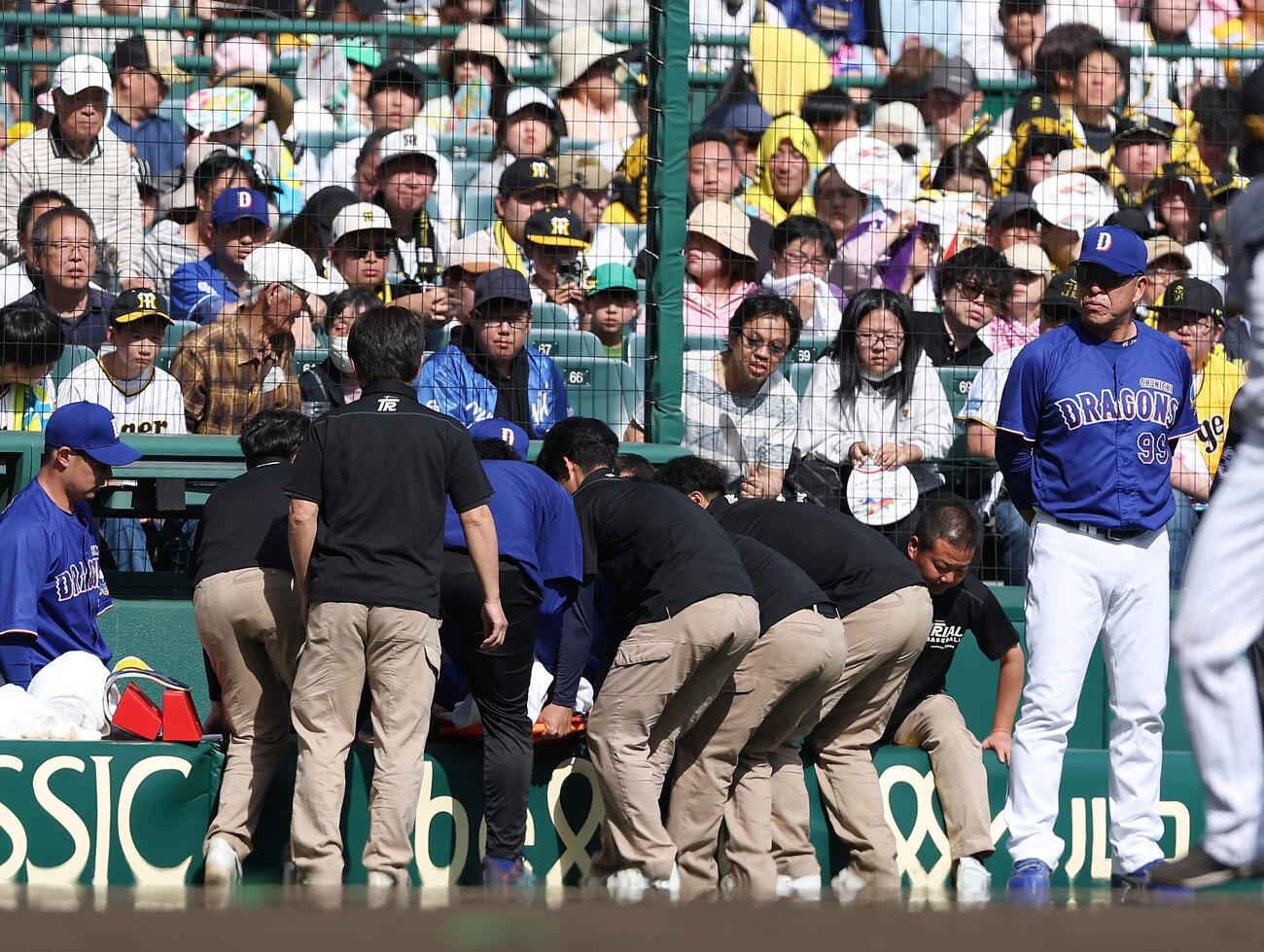 阪神対中日　3回裏阪神2死二塁、カメラマン席に落下し担架で運ばれる三塁手福永。右端は心配そうに駆け寄った井上監督（撮影・前田充）