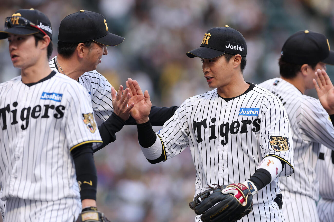 阪神対中日　中日に勝利し藤川監督（左から2人目）とタッチを交わす阪神木浪（同3人目）（撮影・前田充）