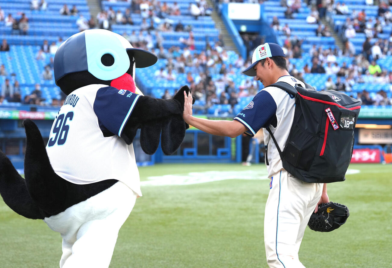 試合前、つば九郎とタッチを交わすヤクルト奥川（撮影・足立雅史）