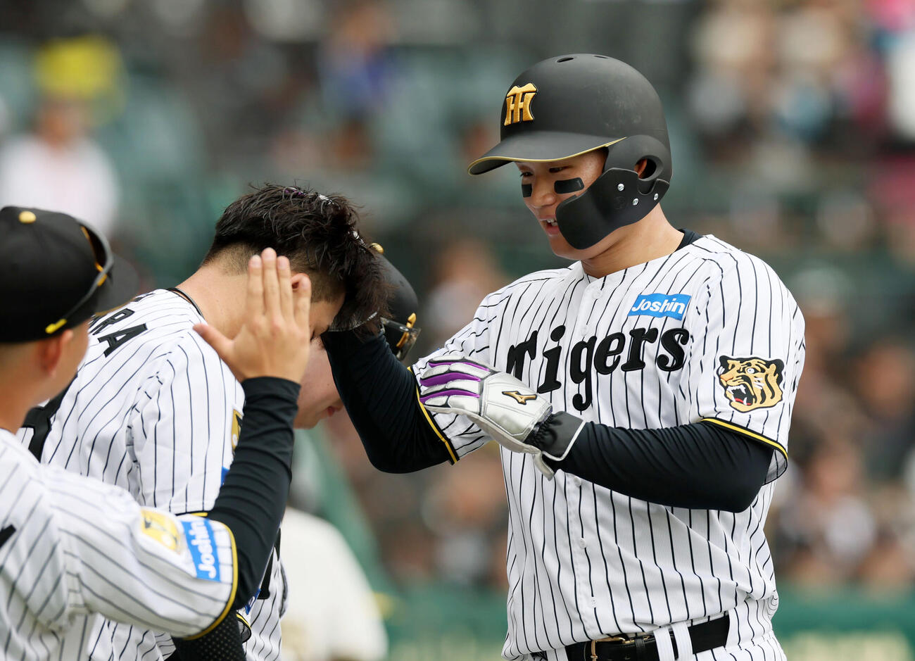 阪神対中日　1回裏阪神1死二塁、二走森下は佐藤の中越え適時三塁打で生還し伊原(左）の頭をなでる（撮影・加藤哉）