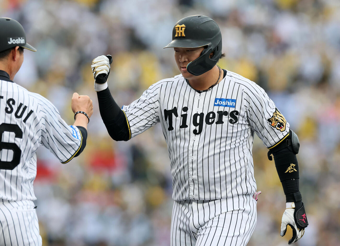 阪神対中日　5回裏阪神2死一、二塁、大山は左前適時打を放ち筒井一塁コーチ(左）とタッチする（撮影・加藤哉）