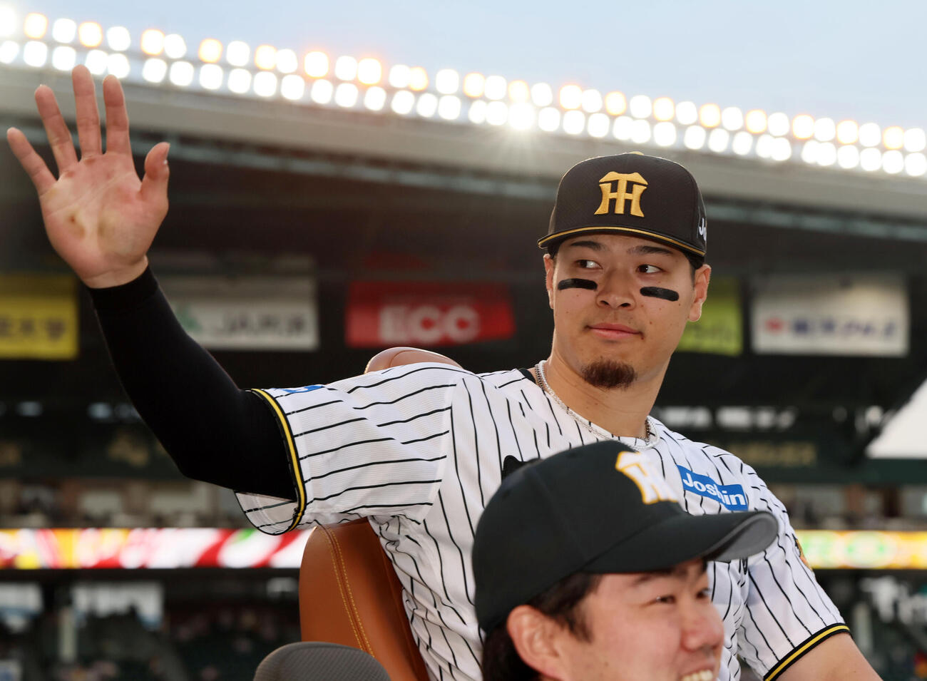 阪神対中日　リリーフカーからスタンドのファンに手を振るヒーローの阪神佐藤（撮影・加藤哉）