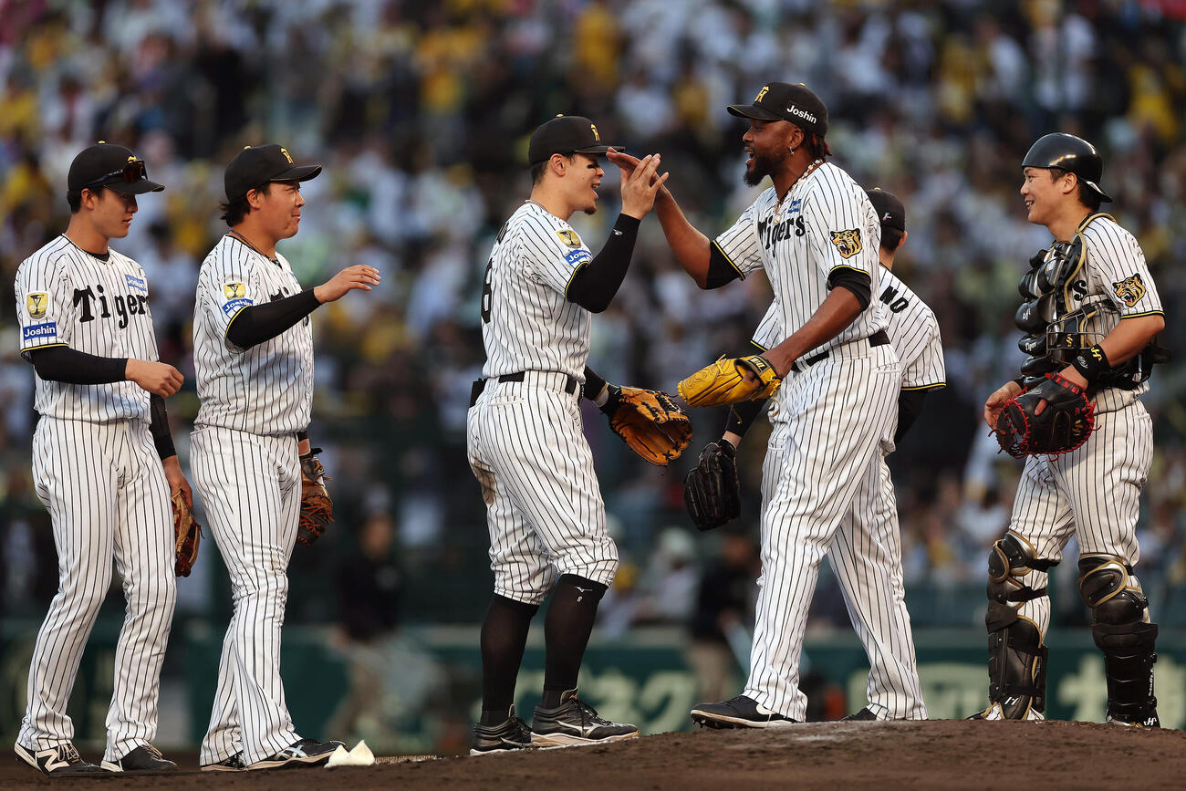 阪神対中日　中日に勝利し、タッチを交わす佐藤（中央）ら阪神の選手たち（撮影・前田充）