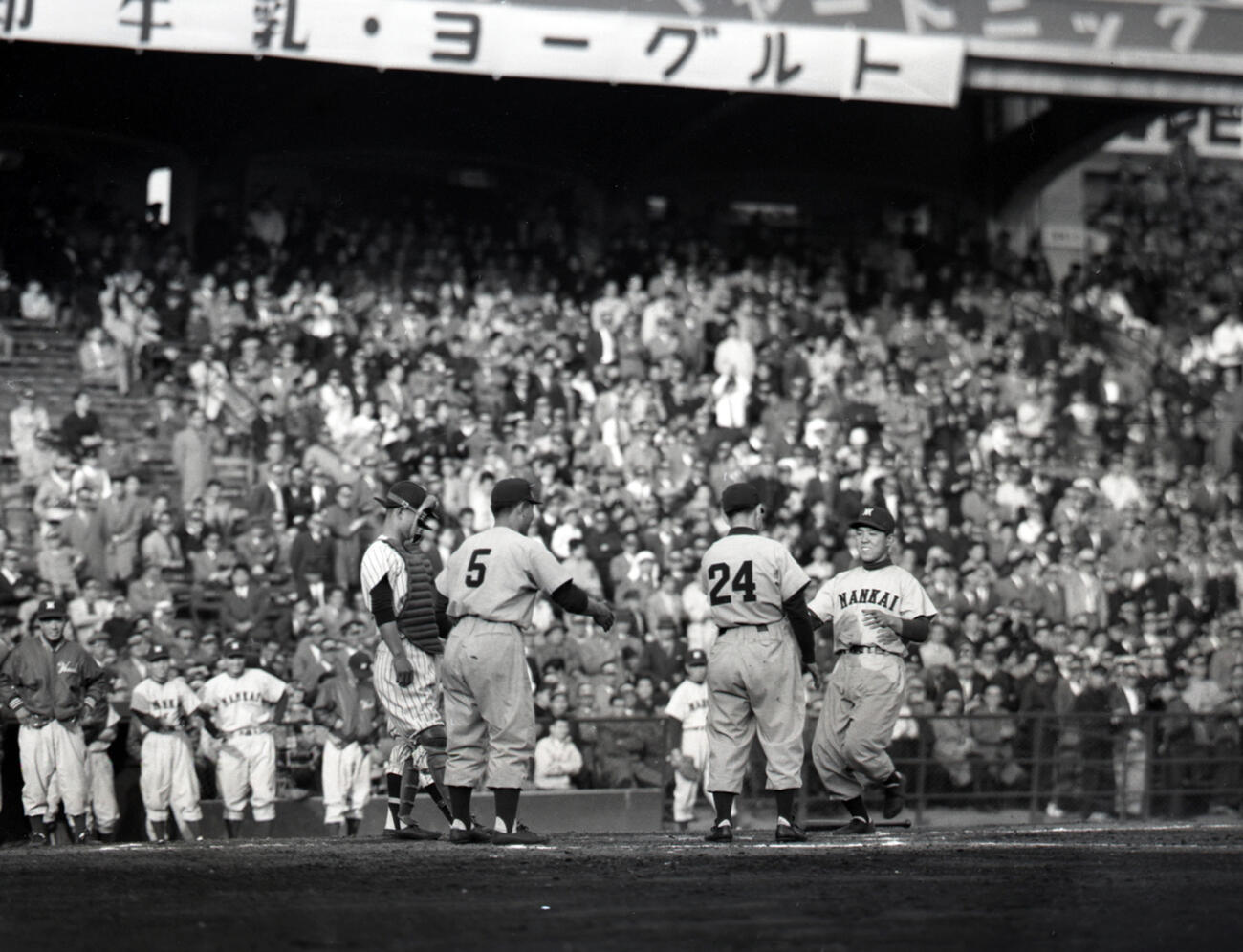 1957年4月、南海対毎日　毎日和田功から左翼へ2号3ランを放った野村克也を迎える岡本伊三美（背番号24）ら