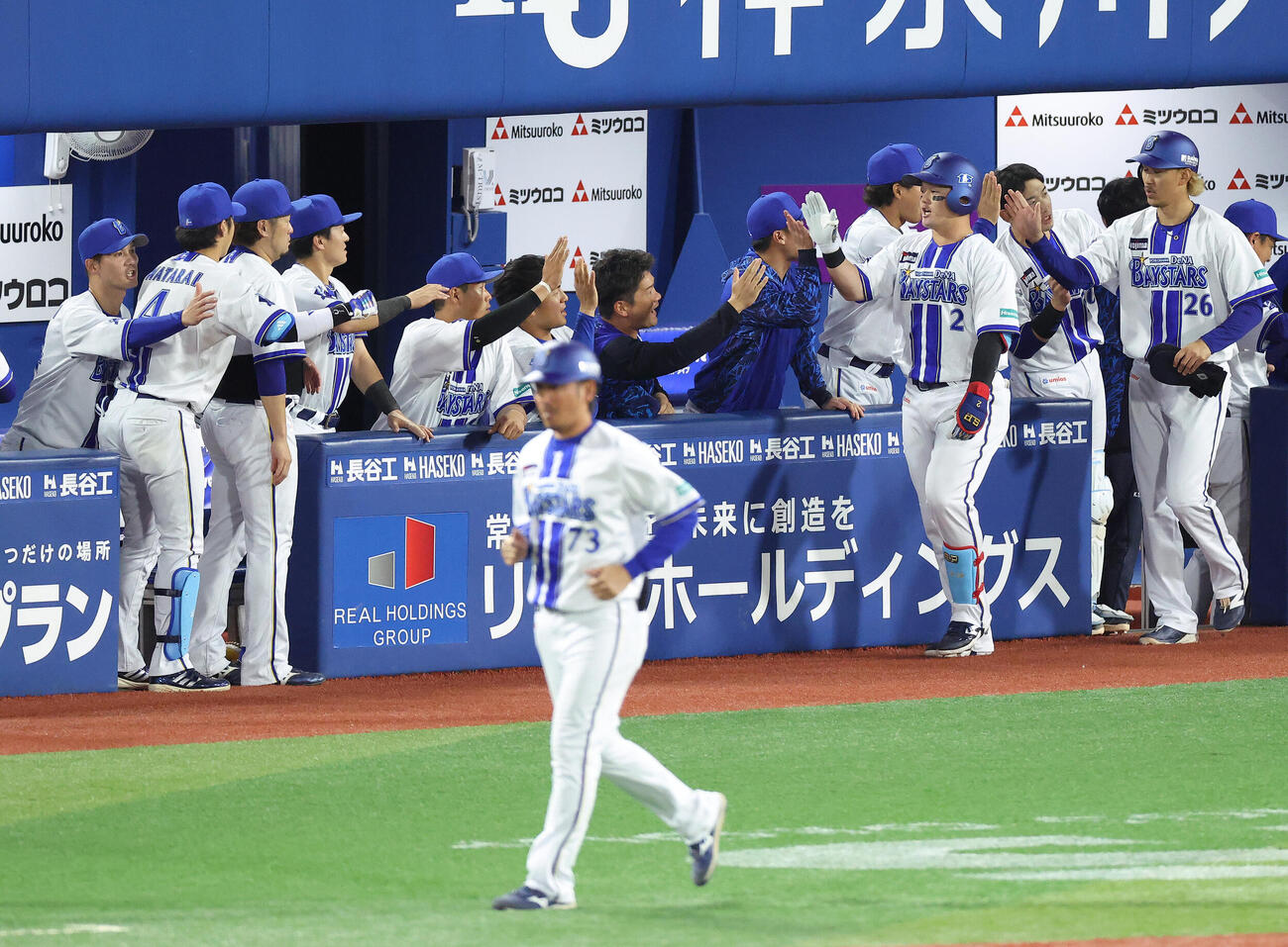DeNA対阪神　3回裏DeNA1死一塁、右中間2点本塁打で生還し、チームメートに迎えられる牧秀悟（右から2人目）（撮影・河田真司）