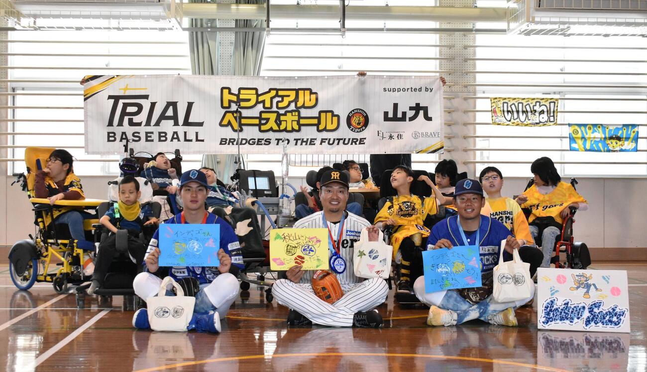 阪神秋山BA（中央）は支援学校の生徒たちと集合写真を撮る（撮影・只松憲）