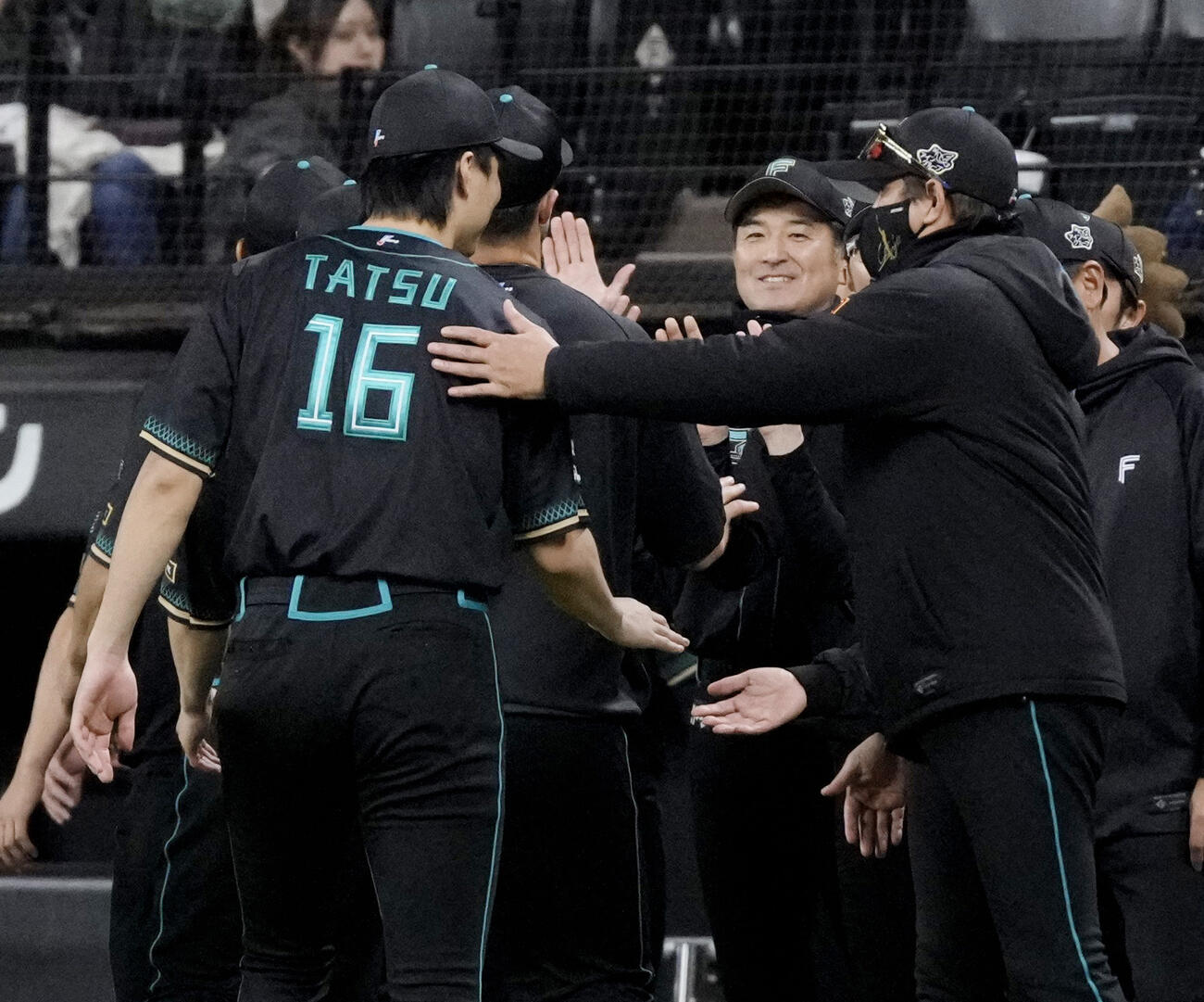 楽天に勝利し、勝利投手の達（16）をねぎらう日本ハム・新庄監督（手前右）＝エスコンフィールド