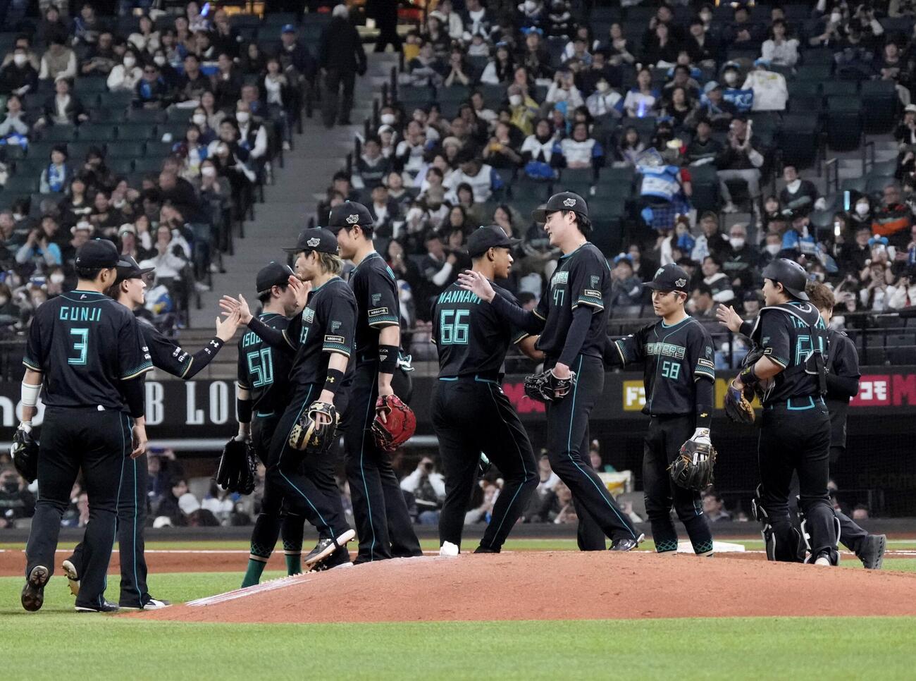 楽天に勝利し、タッチを交わす日本ハムナイン＝エスコンフィールド