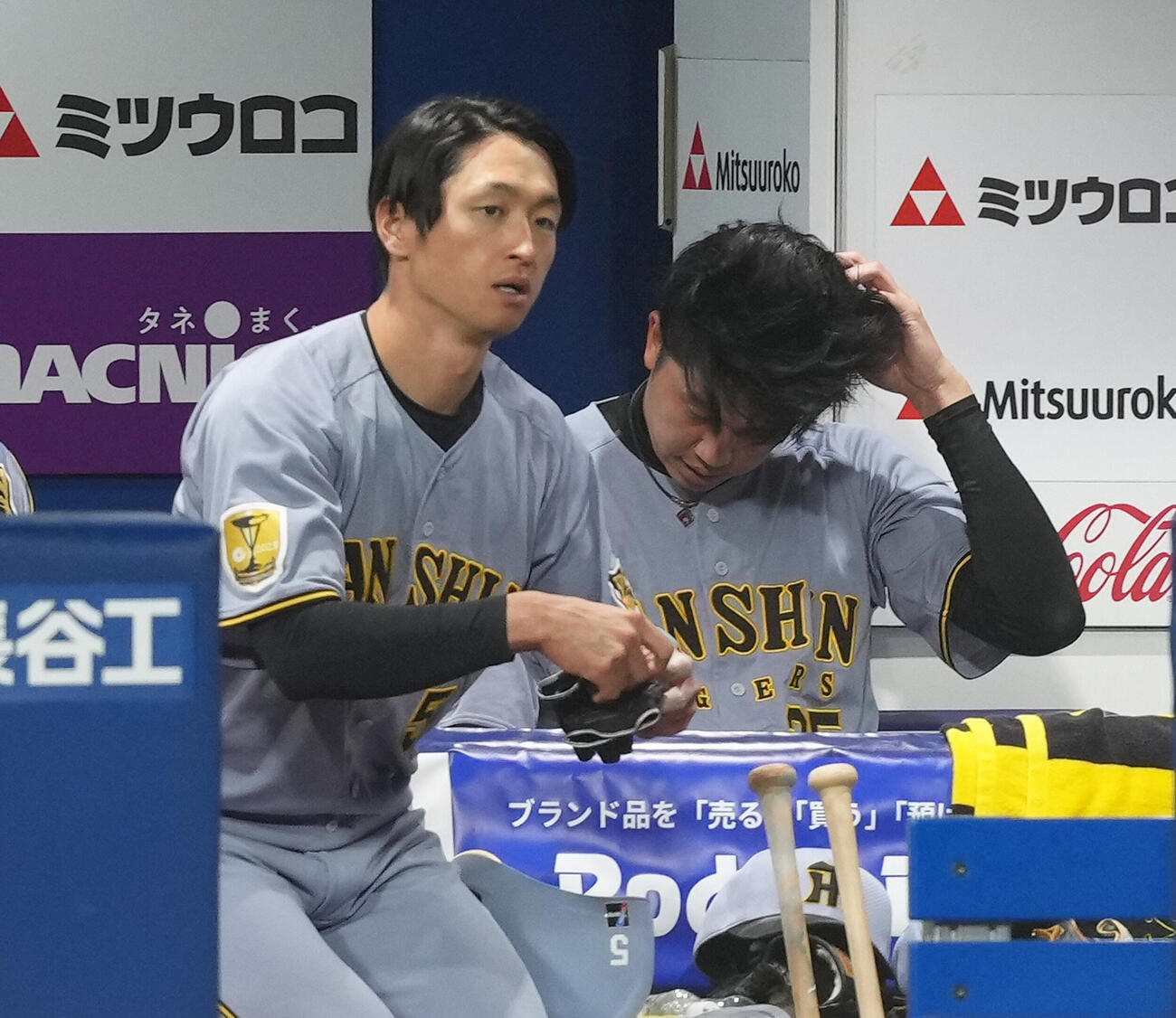 DeNA対阪神　5回6失点の阪神才木浩人はベンチで浮かない顔を見せる。左は近本光司（撮影・足立雅史）