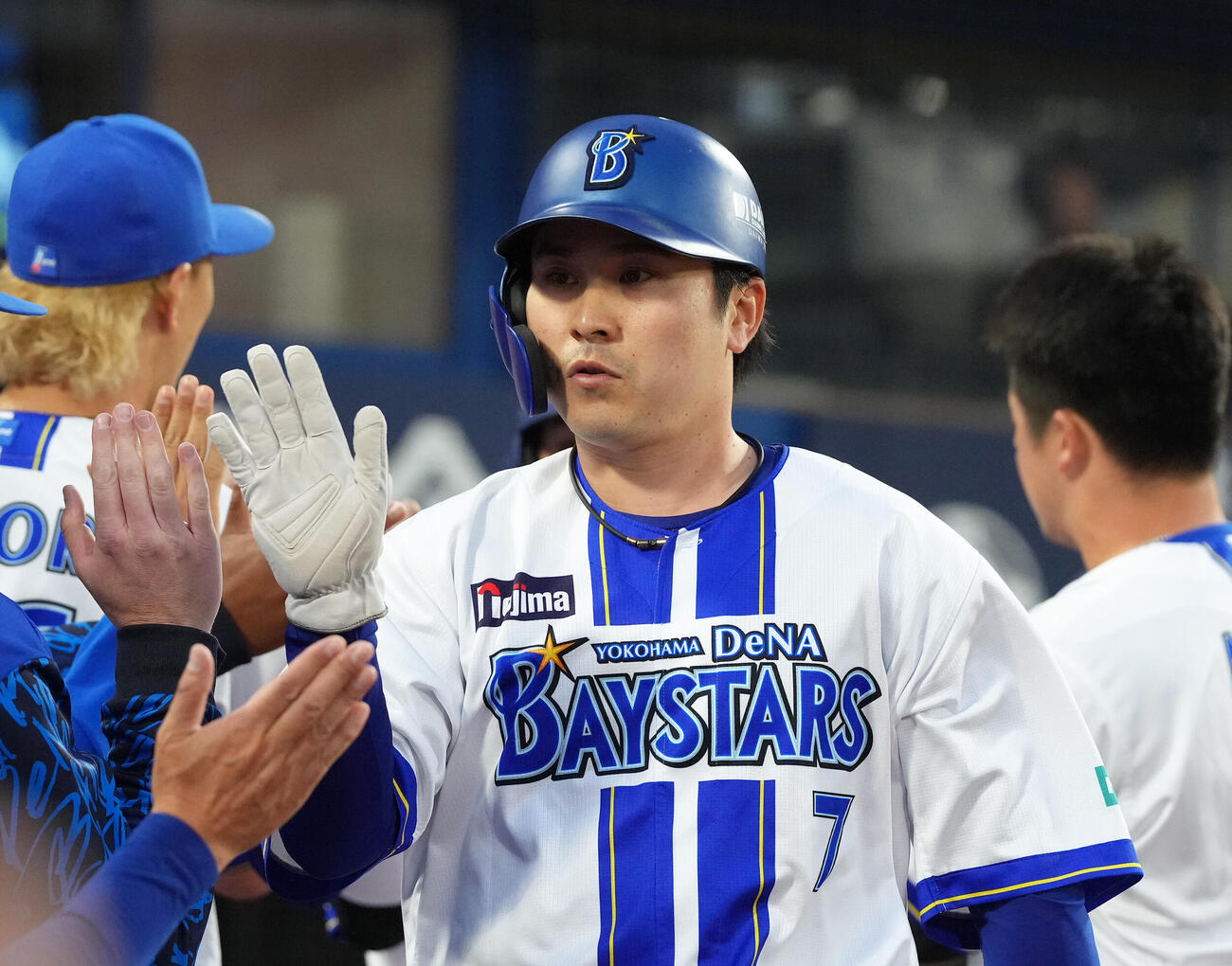 DeNA対阪神　1回裏DeNA1死満塁、戸柱恭孝の適時打で生還しタッチを交わす佐野恵太（撮影・足立雅史）
