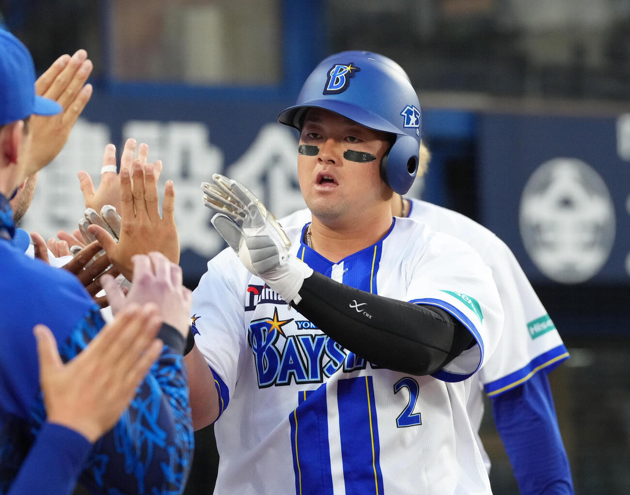 DeNA対阪神　1回裏DeNA1死二、三塁、佐野恵太の先制2点適時打で生還しタッチを交わす牧秀悟（撮影・足立雅史）