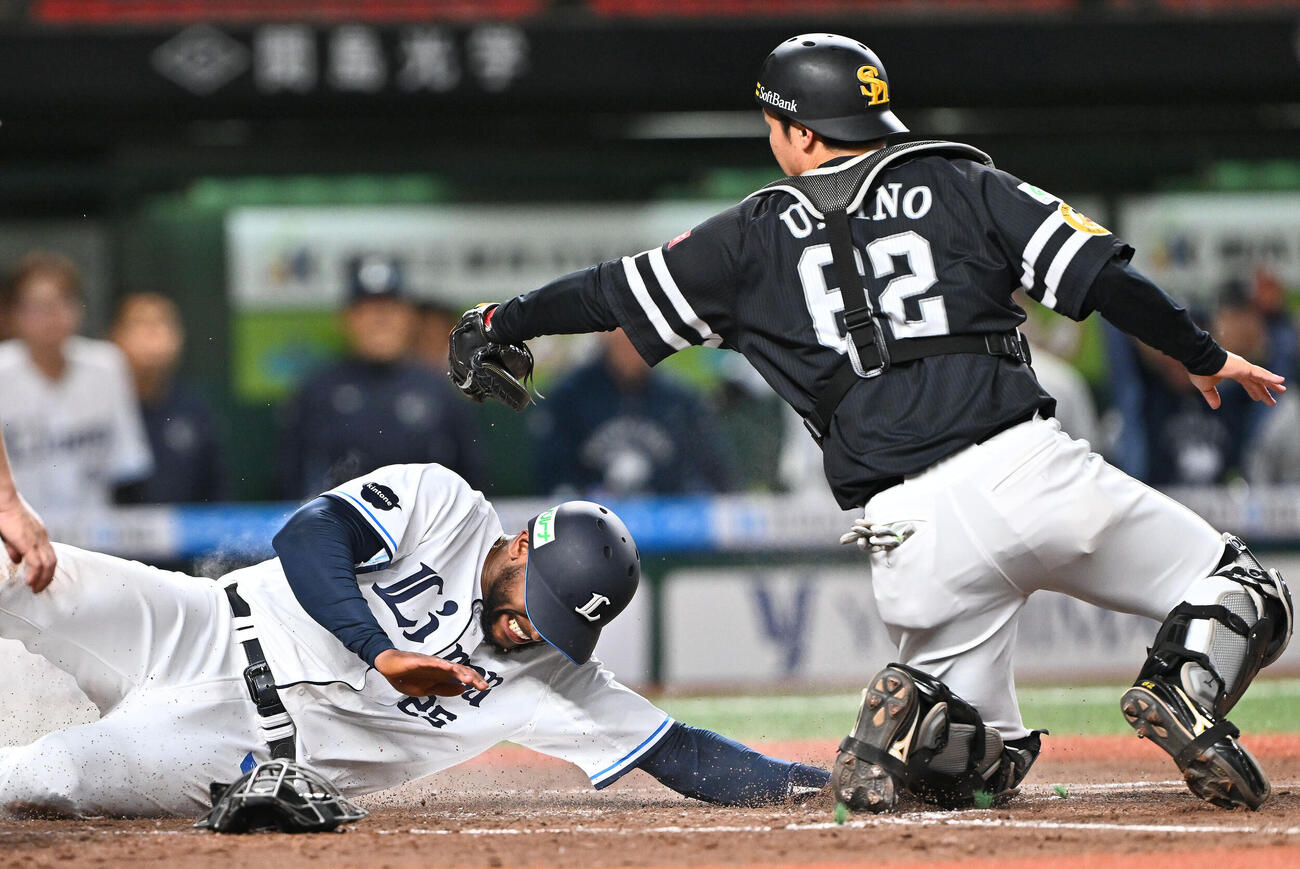 西武対ソフトバンク　4回裏西武無死三塁、岸潤一郎の犠飛で生還するアレクサンダー・カナリオ（左）。捕手海野隆司（撮影・滝沢徹郎）