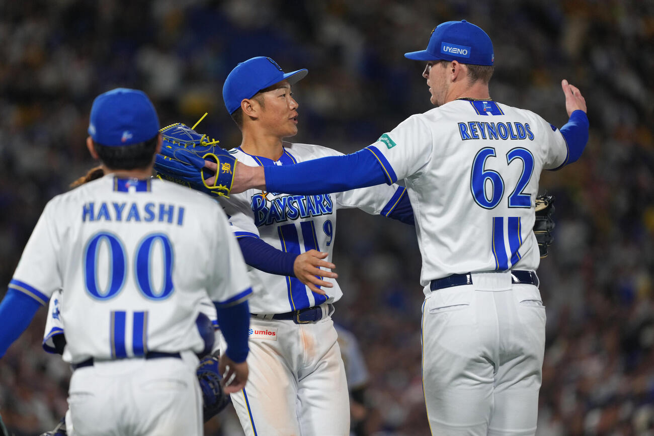 DeNA対阪神　8回表阪神2死満塁、前川右京の打球を好捕した遊撃手京田陽太（中央）を迎えるレイノルズ（撮影・足立雅史）