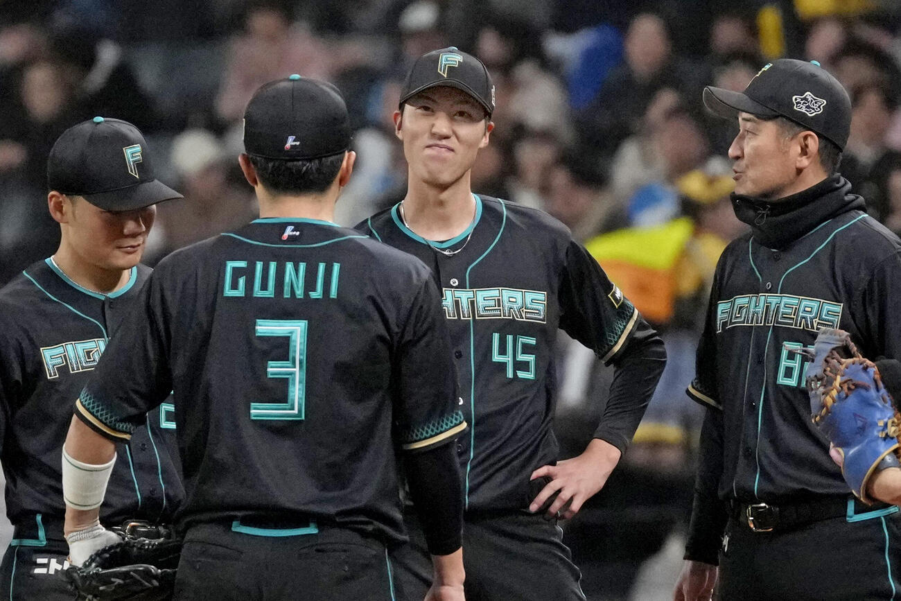 6回、投手交代を告げられ、渋い表情の日本ハム・福島（奥中央）＝エスコンフィールド