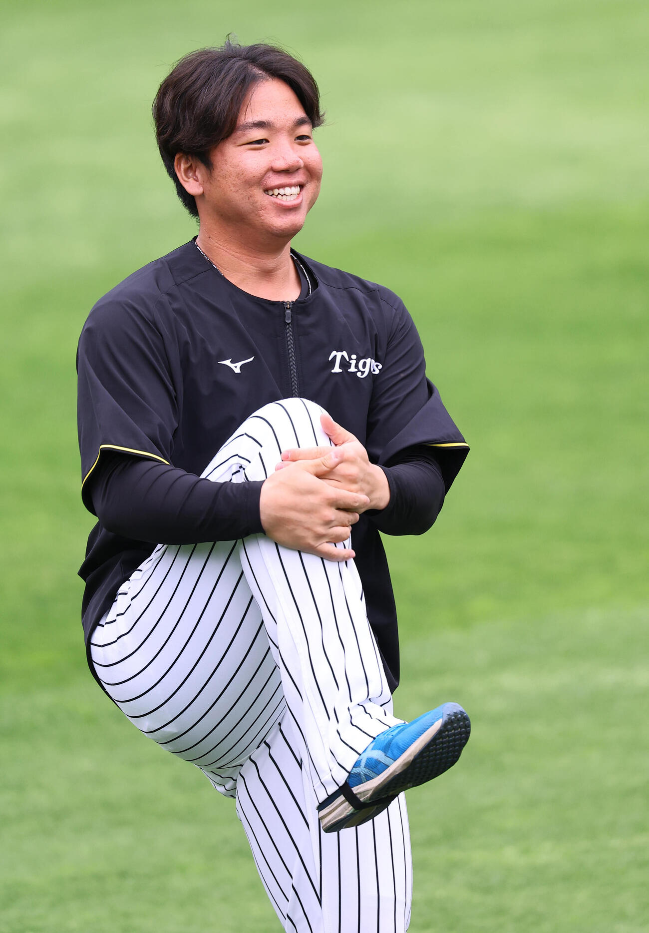 笑顔を見せながらウオーミングアップをする村上頌樹（撮影・上田博志）