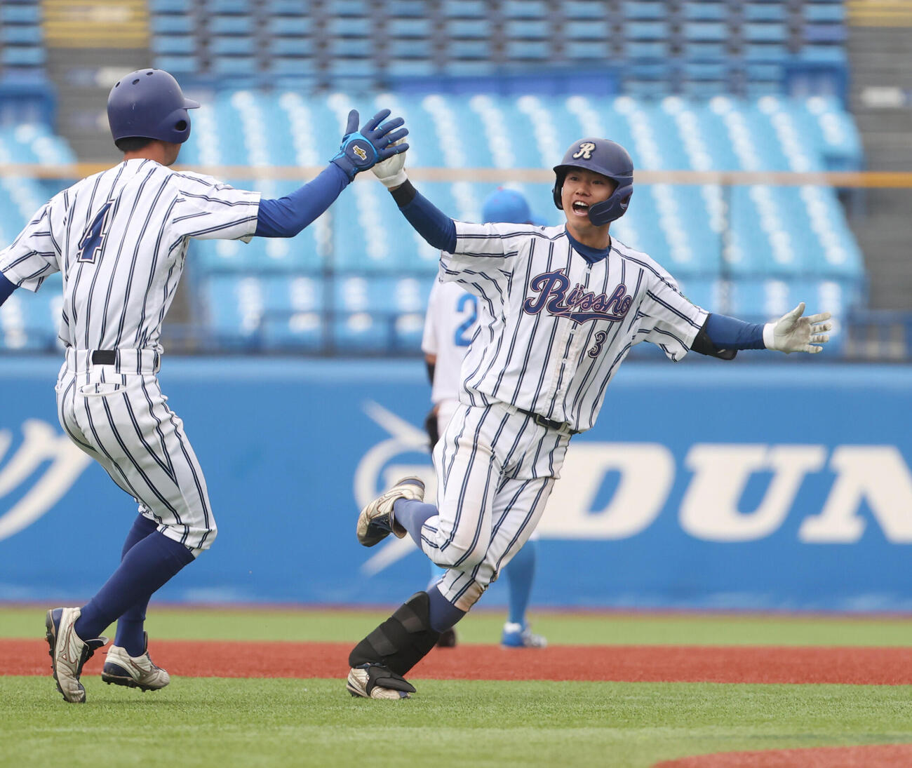 青学大対立正大　タイブレーク11回裏立正大無死満塁、藤崎凌太郎（右）はサヨナラ打を放ちナインとハイタッチする（撮影・柴田隆二）