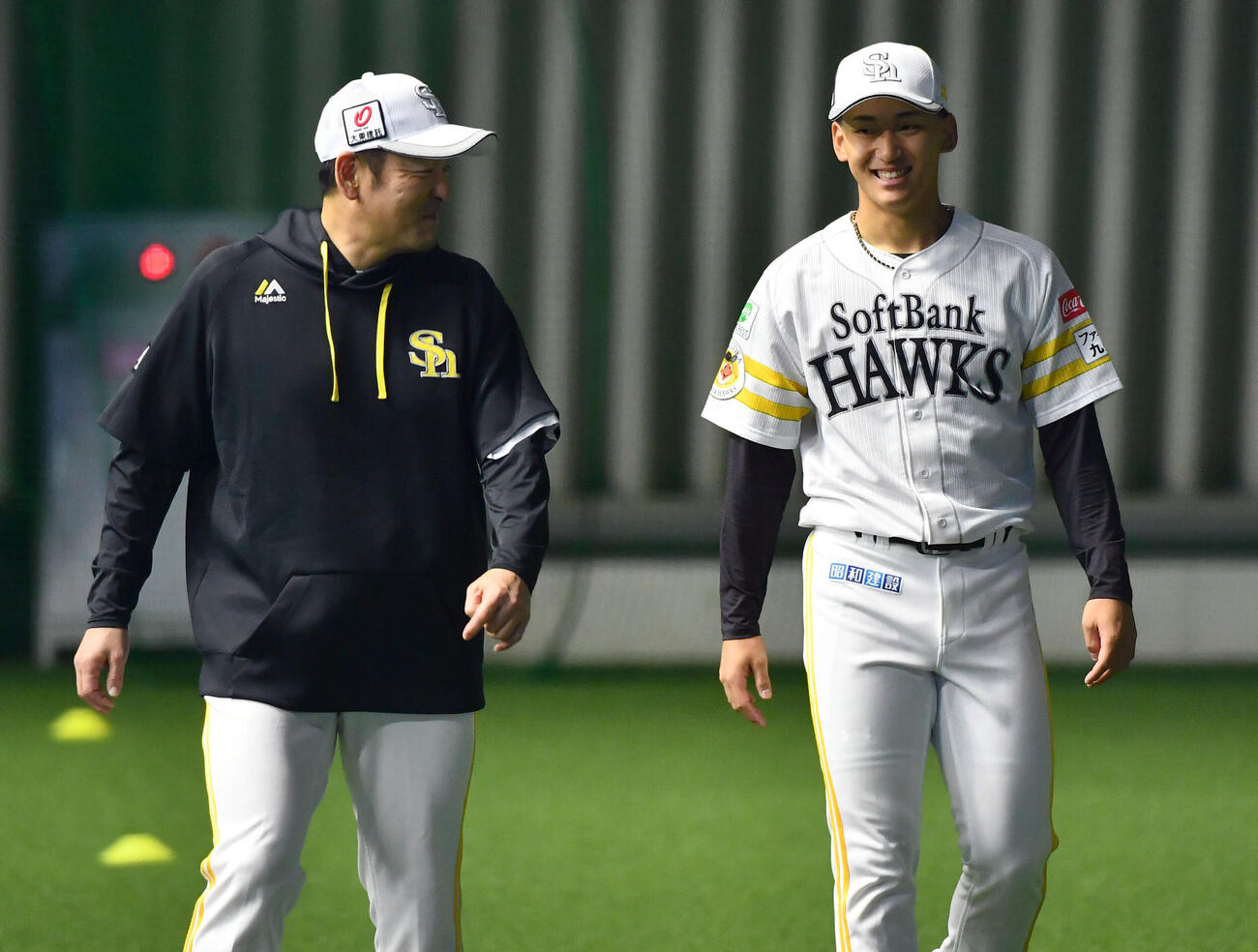 倉野信次投手チーフコーチ兼投手ヘッドコーディネーター（左）と笑顔で話すソフトバンク前田悠伍（撮影・岩下翔太）