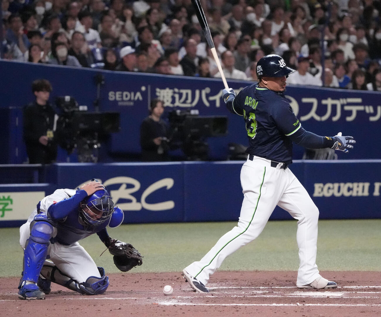 中日対ヤクルト　8回表ヤクルト1死一、二塁、ホセ・オスナ（右）は空振り三振に倒れる際にバットが捕手・石伊雄太の頭に直撃（撮影・森本幸一）