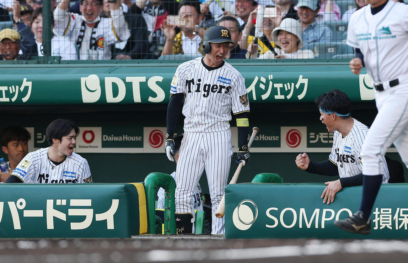 阪神対広島　8回裏阪神2死満塁、小幡竜平が押し出し四球を選びベンチで喜ぶ、左から中野拓夢、近本光司、森下翔太（撮影・前田充）
