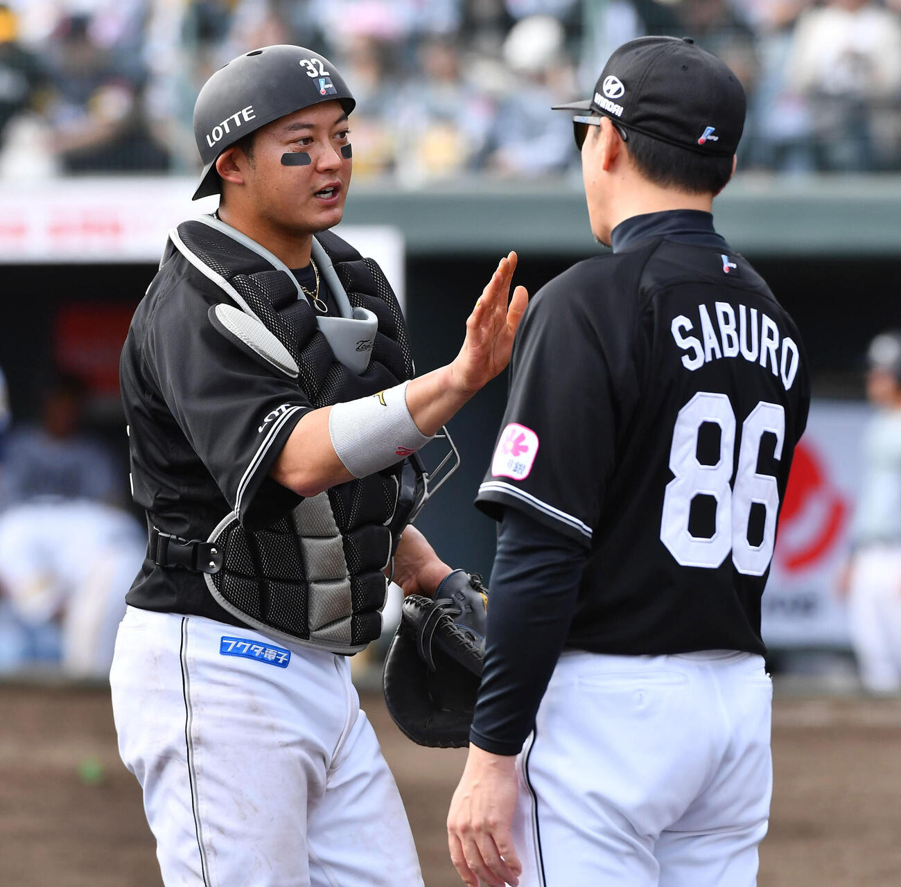 ソフトバンク対ロッテ　ソフトバンクに勝利し、サブロー監督（右）とハイタッチする佐藤都志也（撮影・岩下翔太）