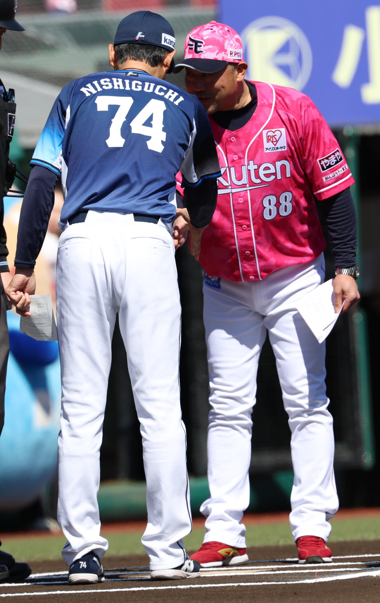 楽天対西武　メンバ表を交換する西武西口文也監督（左）と楽天三木肇監督（撮影・水谷安孝）