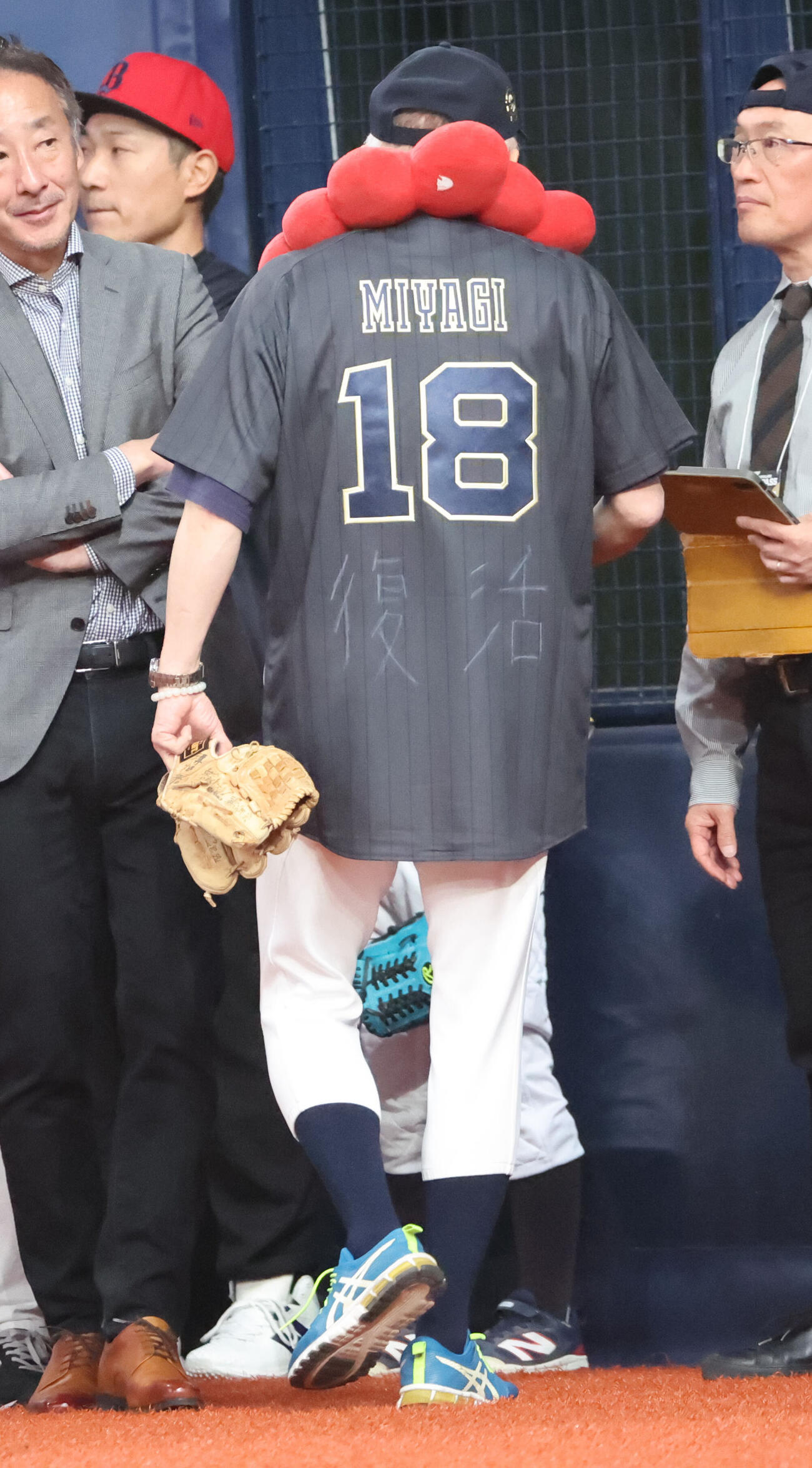 オリックス対日本ハム　始球式に備え、入念に準備する大阪観光局の溝畑宏理事長。首にはミャクミャク、ユニホームは宮城大弥のもので、「復活」と書かれていた（撮影・西尾就之）