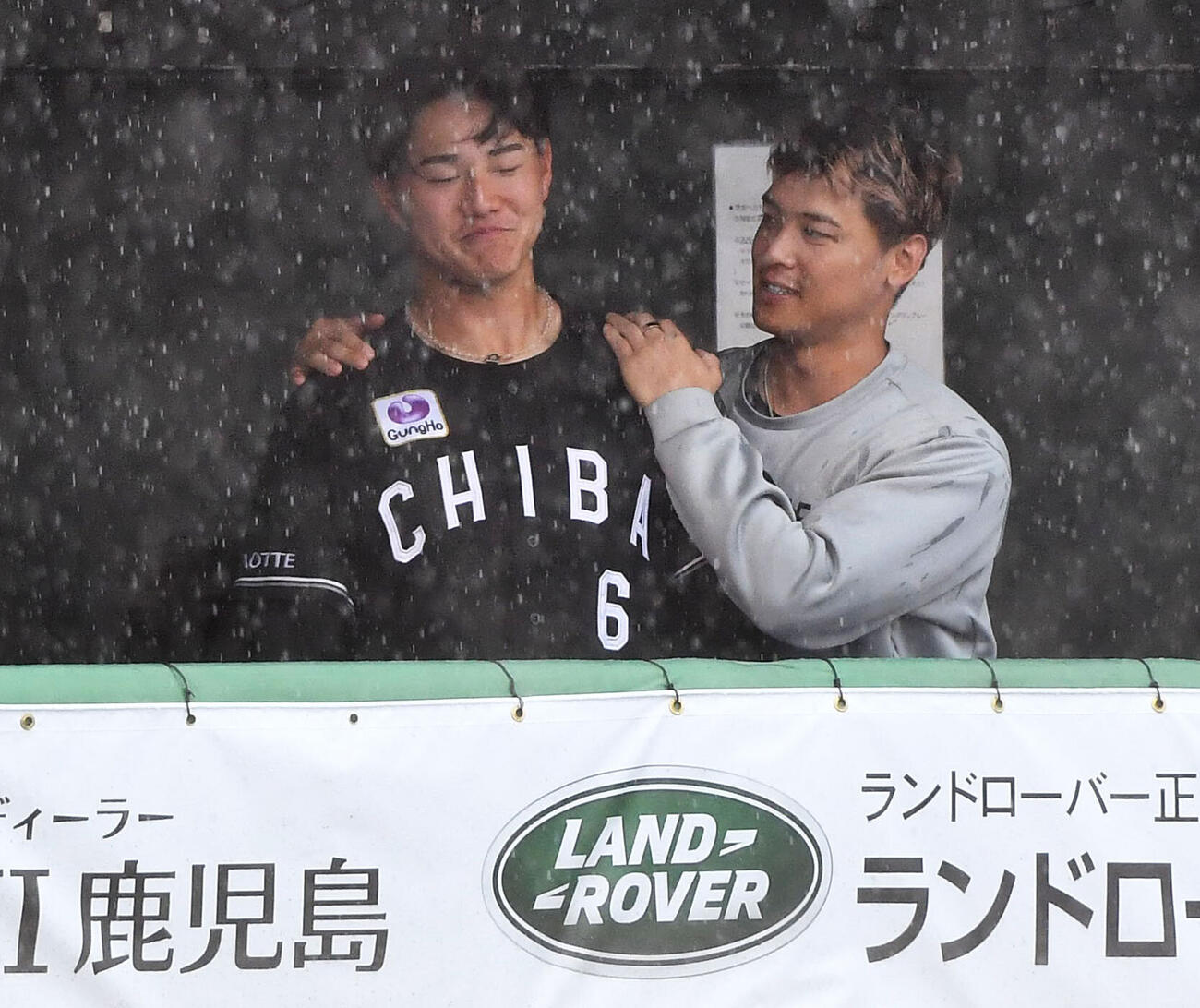 ソフトバンク対ロッテ　雨で試合中断中、ベンチで石川慎吾（右）から声をかけられるロッテ西川史礁（撮影・岩下翔太）