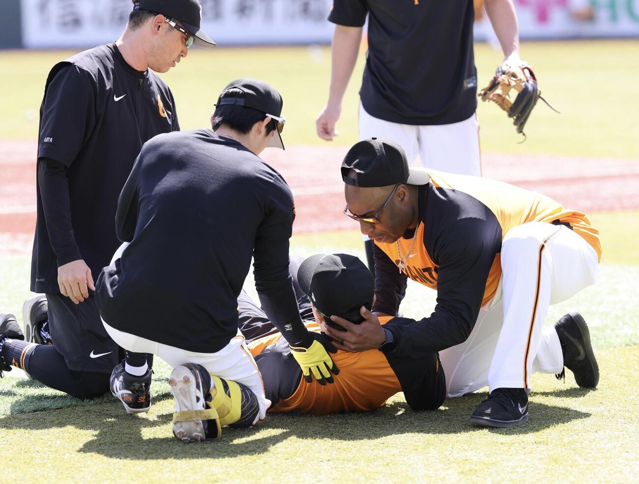 巨人対中日　試合前練習中、フリー打撃の打球が、顔に当たった巨人泉口友汰(手前)にコーチ、スタッフがかけよる(撮影・浅見桂子)