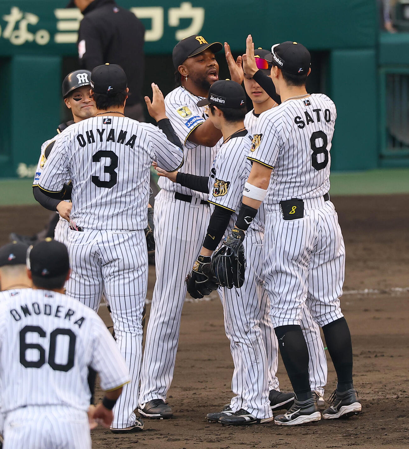 阪神対広島　試合を締めたラファエル・ドリス（中央）は佐藤輝明（右）らナインとハイタッチをする（撮影・上田博志）