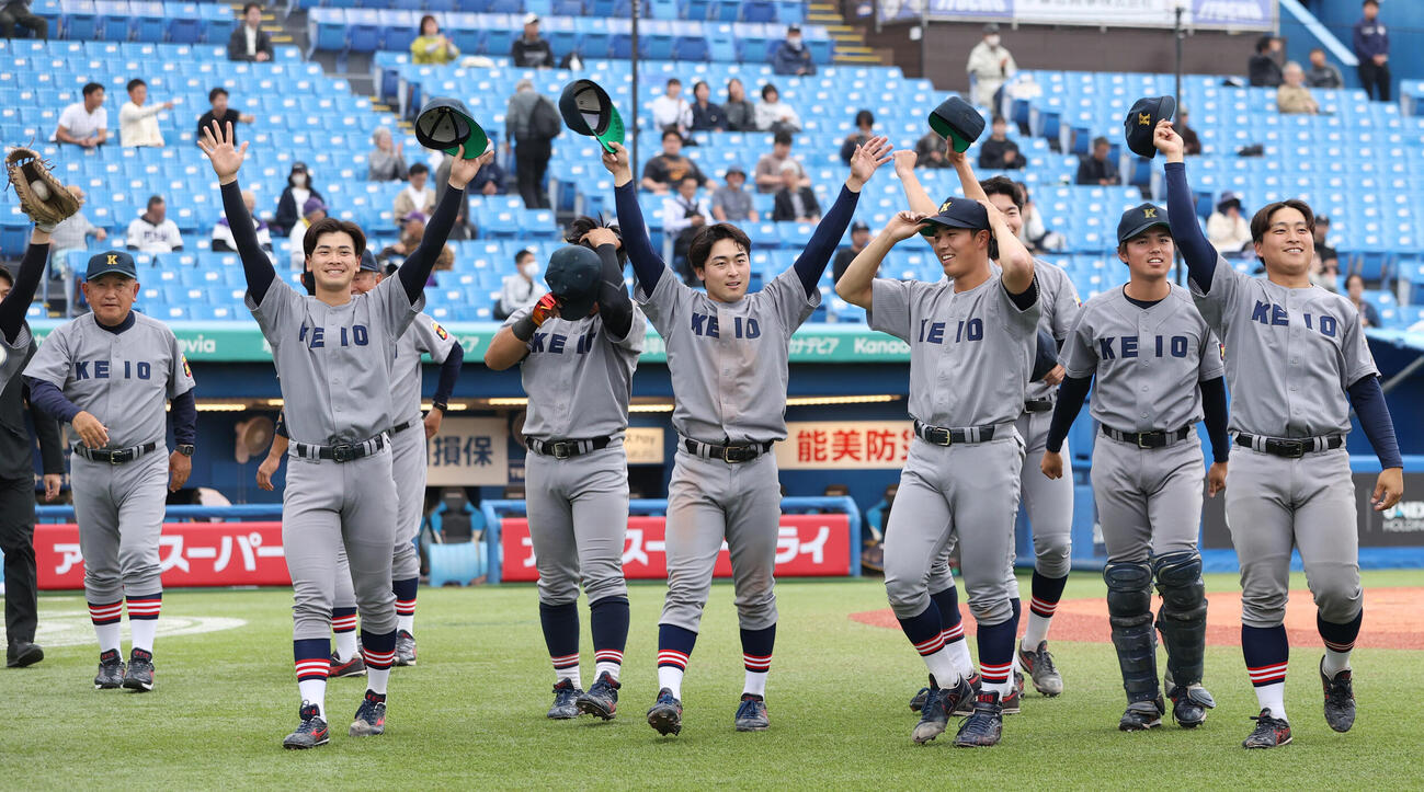 6大学野球　明大対慶大　勝利した、左から慶大・堀井哲也監督、渡辺和大らナインスタンドに手を振る（撮影・柴田隆二）.