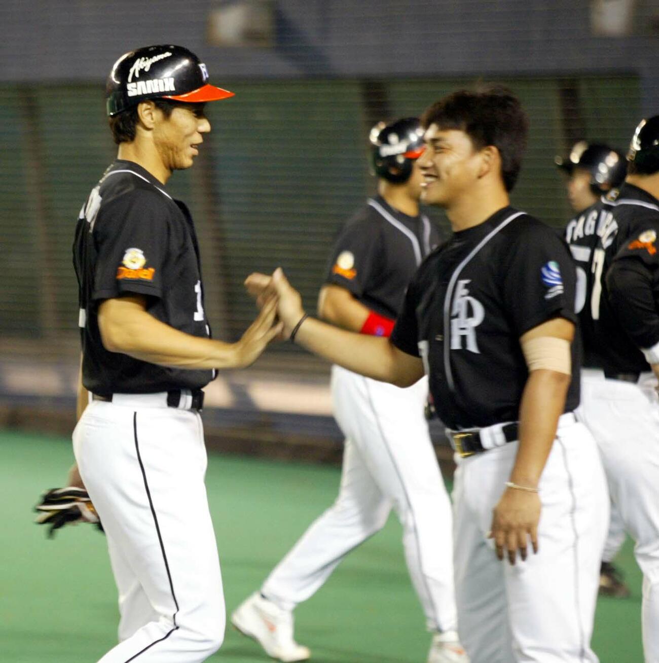ロッテ対ダイエー14回戦　秋山幸二は勝ち越しの適時打を放ちベンチで井口資仁に迎えられ笑顔を見せる＝千葉マリンスタジアム(2002年7月撮影)