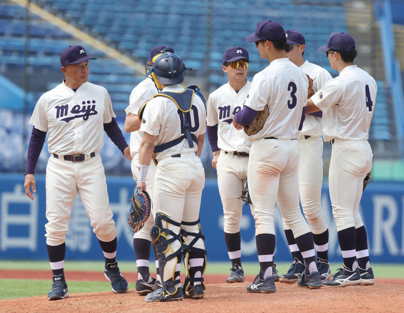 6大学野球　明大対慶大　5回裏慶大1死満塁のピンチにマウンドに集まる明大ナイン、左端は戸塚俊美監督（撮影・柴田隆二）.