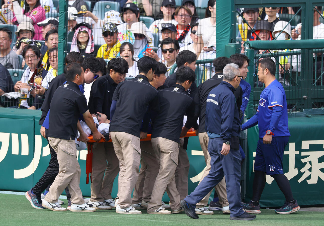 18日の阪神対中日　3回裏阪神2死二塁、カメラマン席に飛び込み負傷した福永は担架で運ばれる（撮影・上田博志）