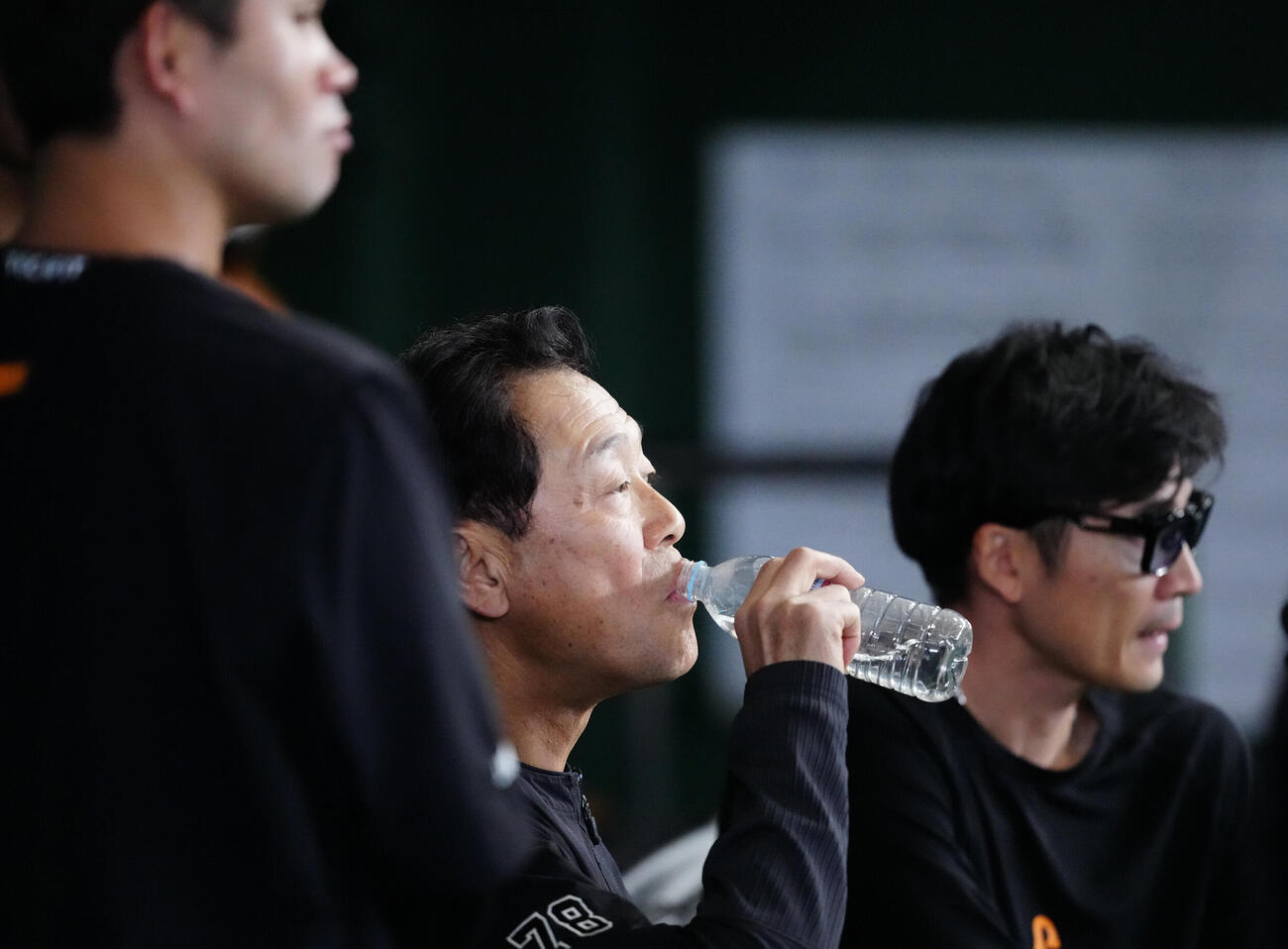 巨人対広島　試合前練習中、ボールが側頭部に当たった巨人川相昌弘ディフェンスチーフコーチ（中央）はベンチで水を飲む（撮影・江口和貴）