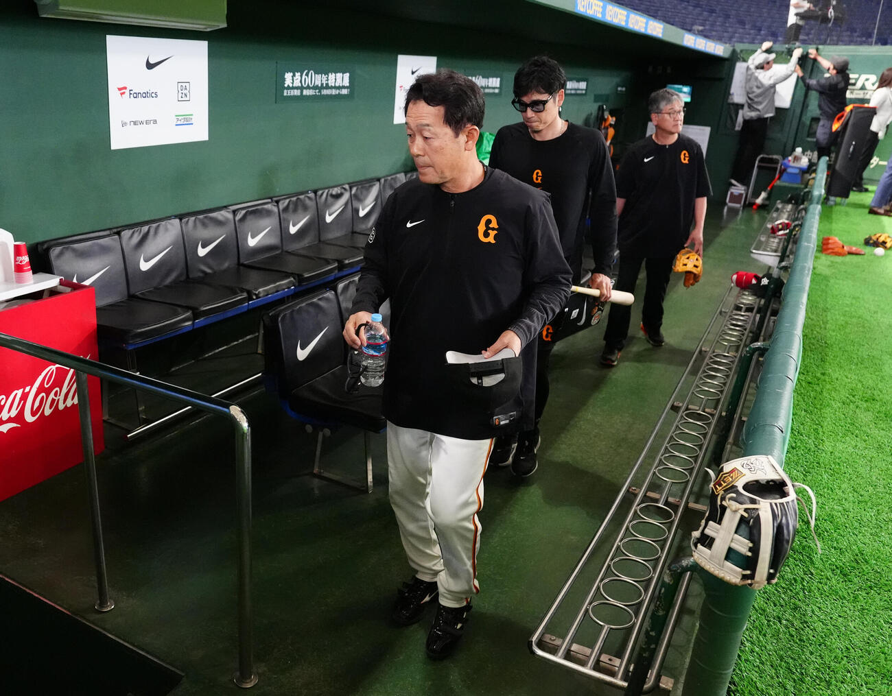 巨人対広島　試合前練習中、ボールが側頭部に当たり、ベンチ裏に引き揚げる巨人川相昌弘ディフェンスチーフコーチ（撮影・江口和貴）