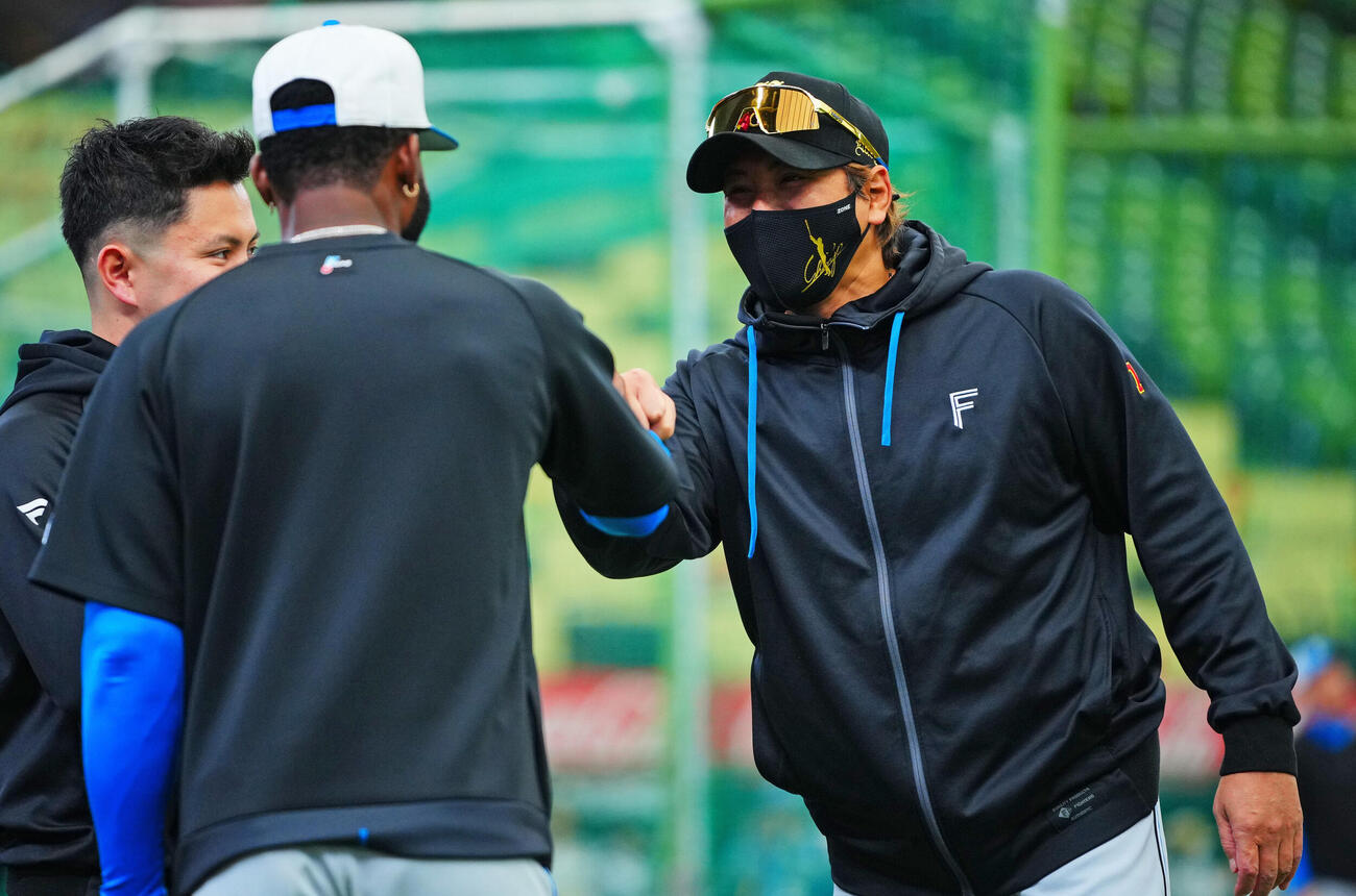 西武対日本ハム　試合前、日本ハム新庄剛志監督（右）はロドルフォ・カストロと話しグータッチを交わす（撮影・垰建太）　