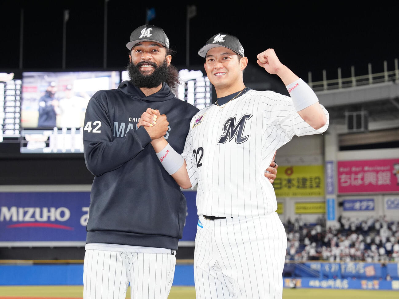 ロッテ対楽天　笑顔で握手を交わすロッテ佐藤都志也（右）とアンドレ・ジャクソン（撮影・鈴木みどり）
