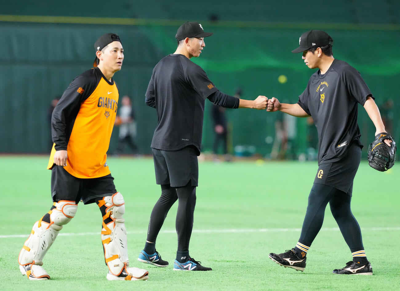 巨人対広島　試合前練習中、巨人大城卓三（右）とタッチを交わす戸郷翔征。左は小林誠司（撮影・江口和貴）